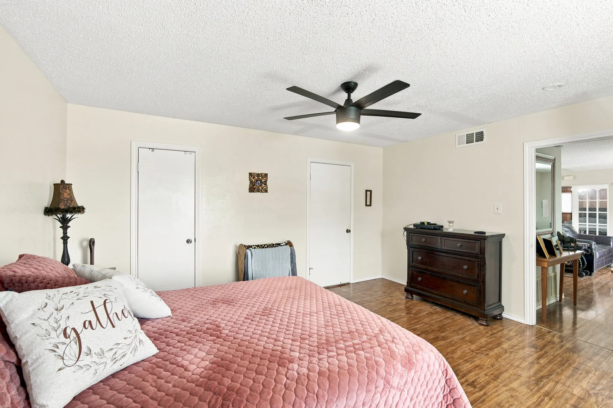 Interior space featuring wood-finish flooring, a contemporary ceiling fan with integrated lighting, and light-toned walls