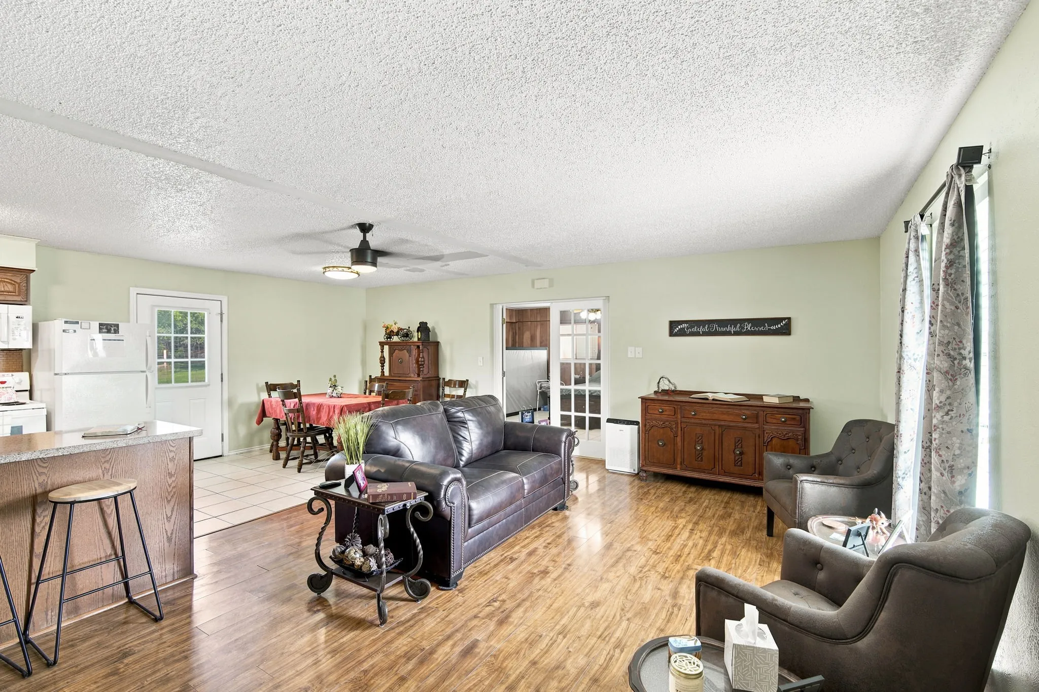 Open-concept living area featuring wood-finish flooring and light green wall paint