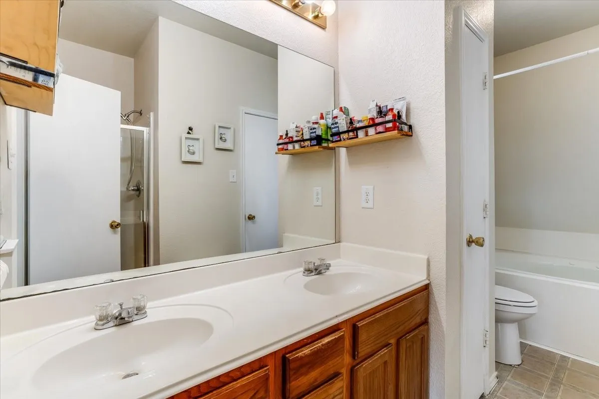 Primary bathroom vanity featuring dual integrated sinks