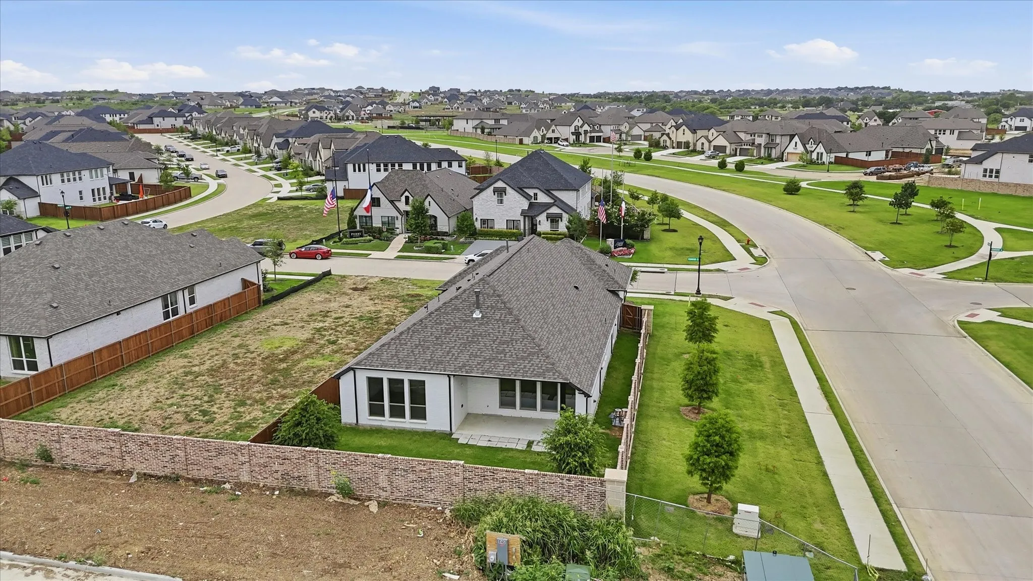 New construction residence featuring a light-colored exterior, multiple large windows, and a covered back patio