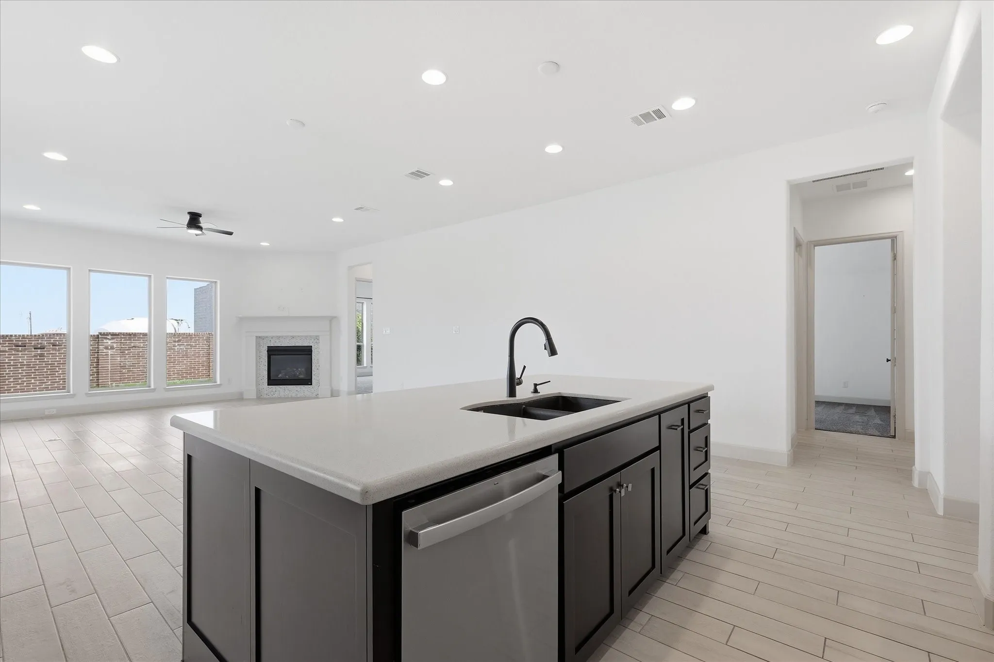 Kitchen island featuring a single-basin sink with a matte black faucet and a stainless steel dishwasher