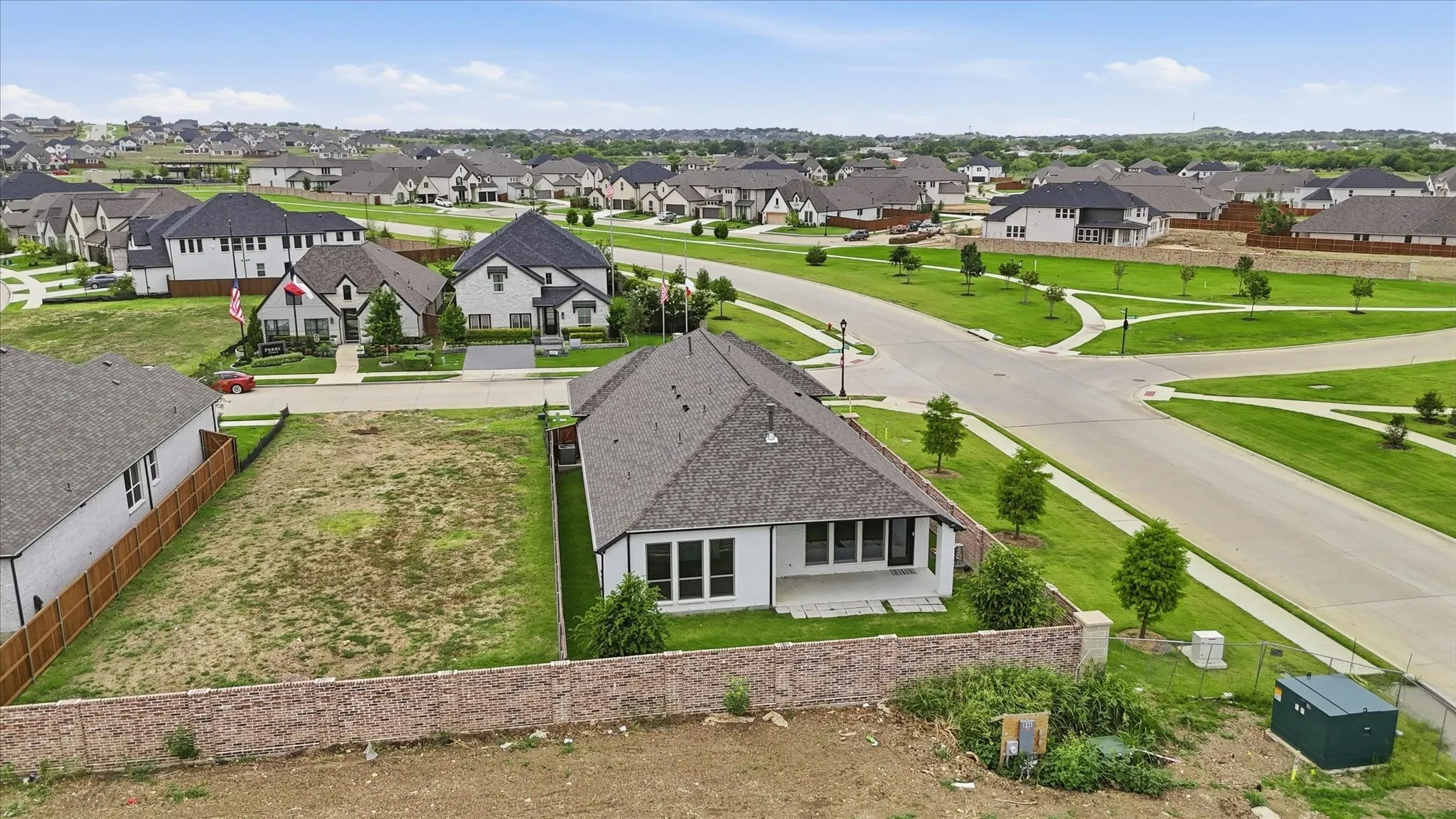 Spacious residential lot featuring a level building area, a partial retaining wall, and established surrounding properties