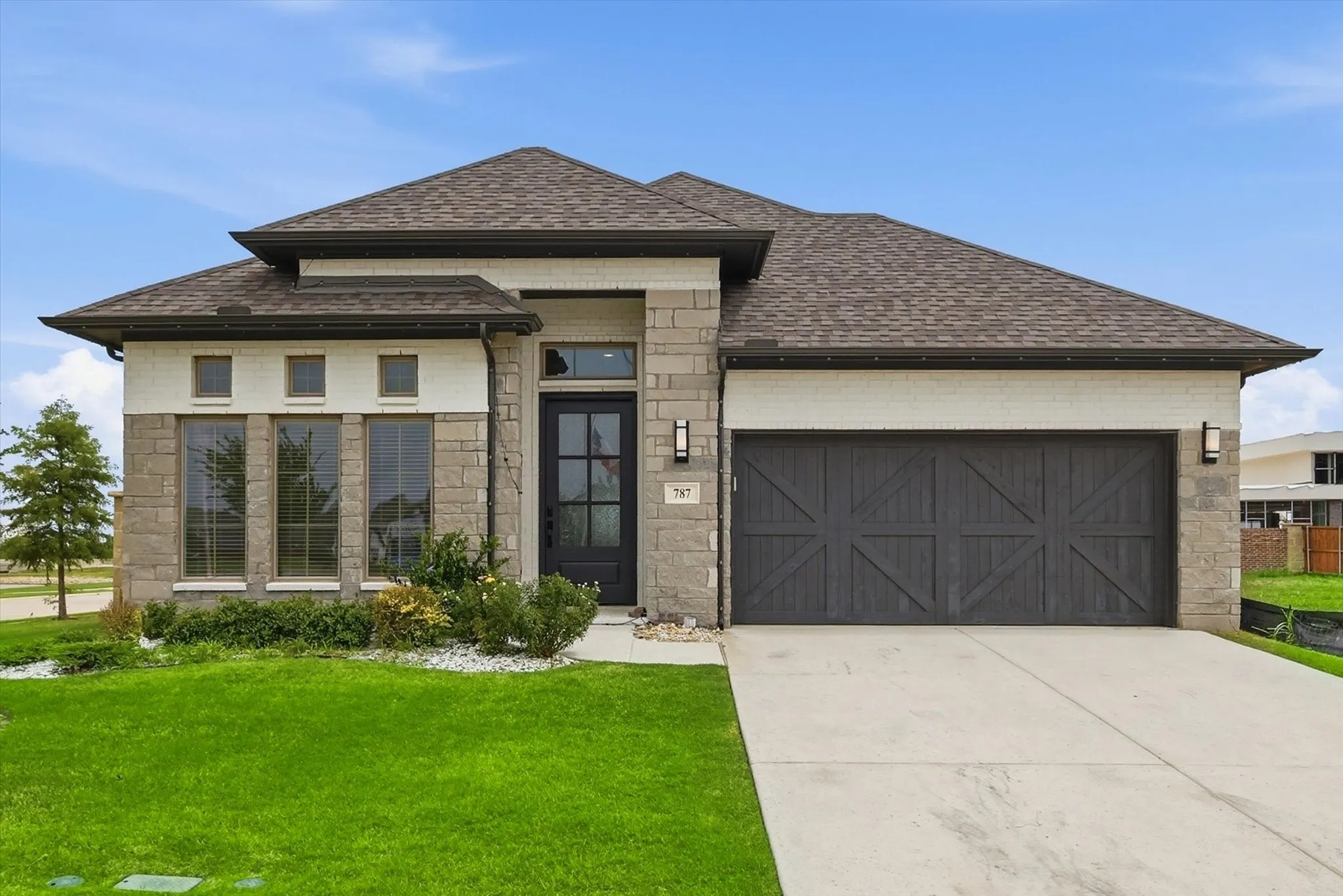 Stone and brick facade with a dark wood-finish garage door