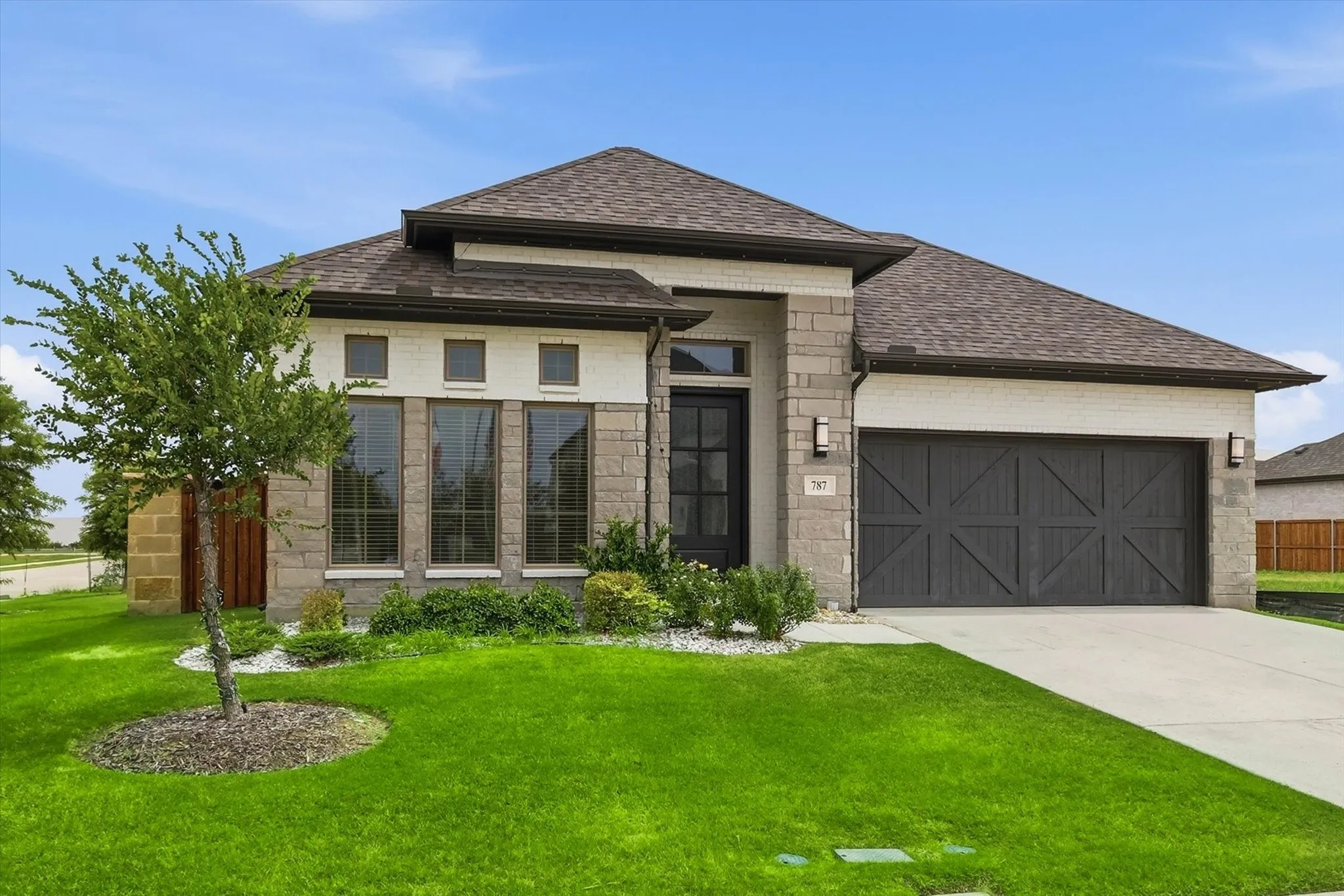 Stone and brick facade with a dark shingle roof