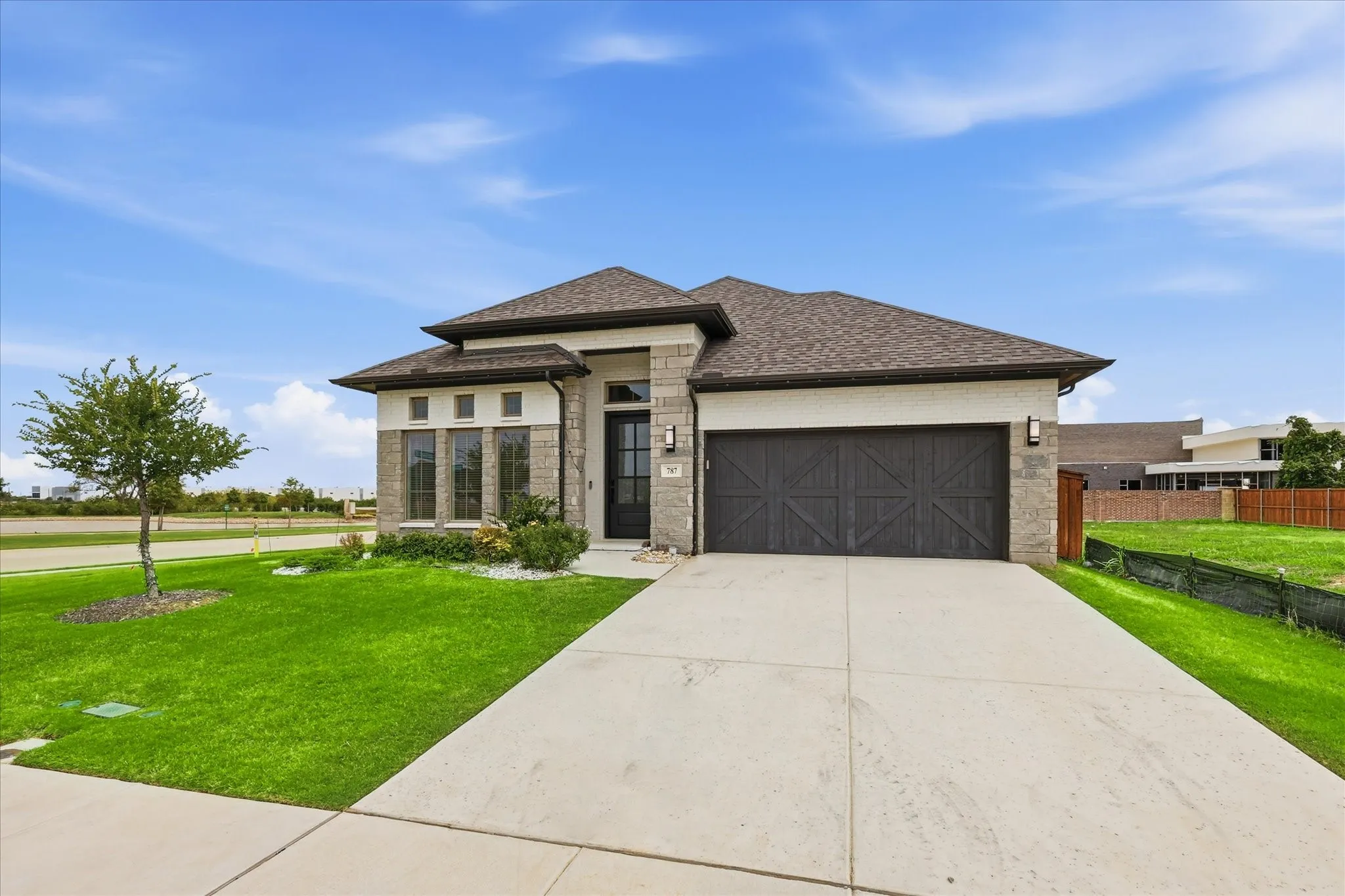 Contemporary single-story residence with a dark brown shingle roof and light brick facade