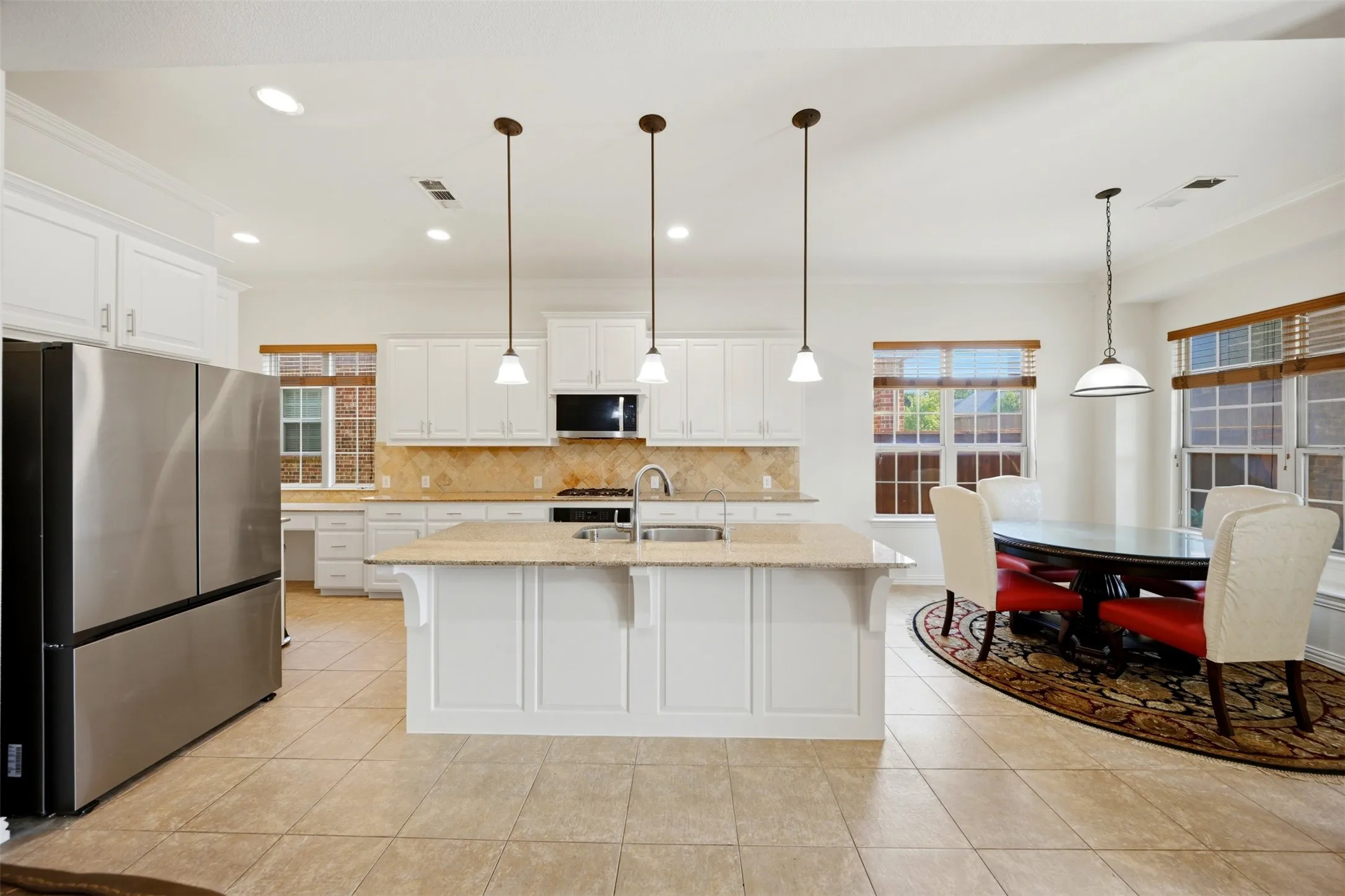 Open-concept kitchen with white cabinetry, stainless steel appliances, and a central island