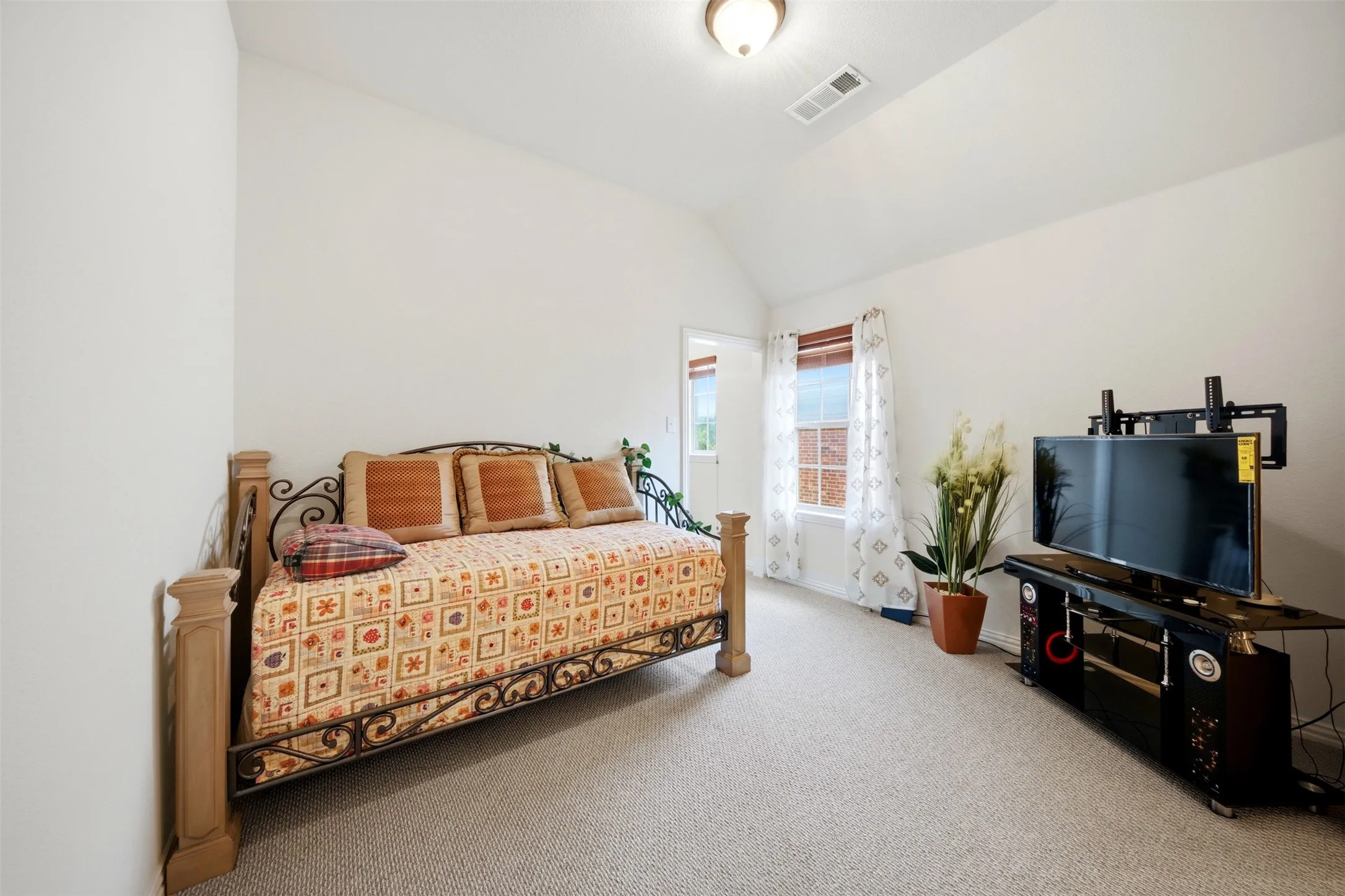 Carpeted room with a vaulted ceiling, recessed lighting, and a window with blinds