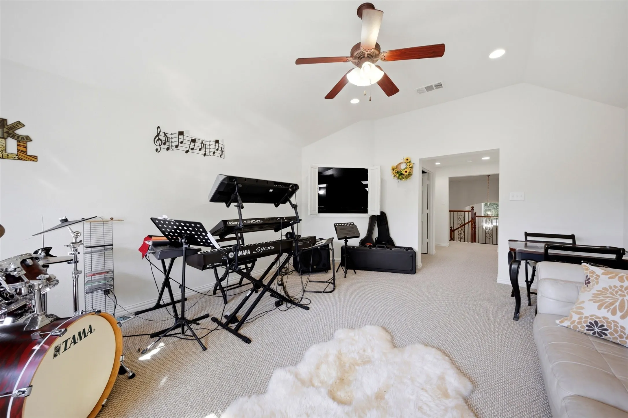 Spacious room featuring vaulted ceilings, recessed lighting, and a ceiling fan