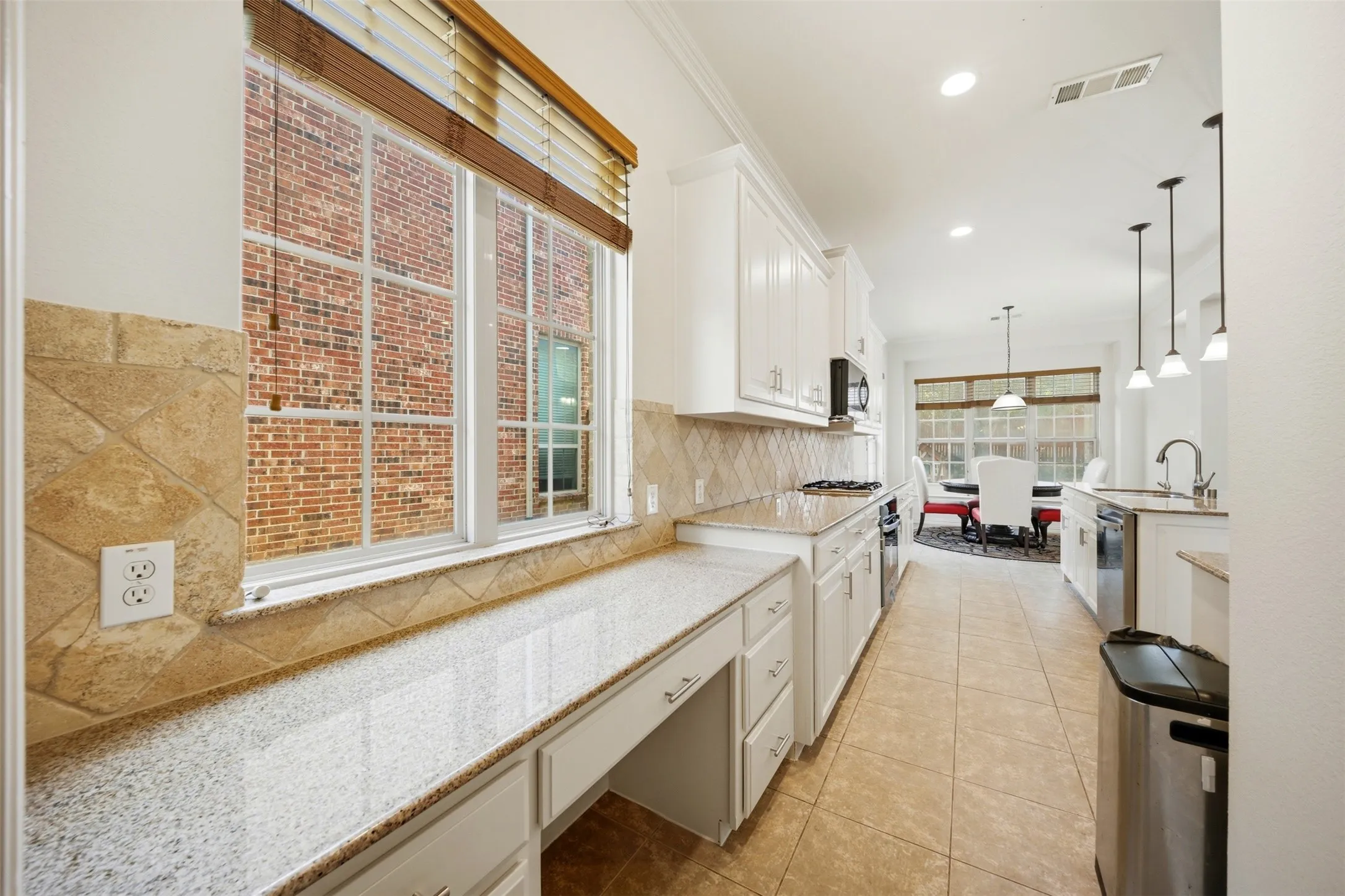Kitchen featuring white cabinetry, light-toned granite countertops, a tiled backsplash, and recessed lighting