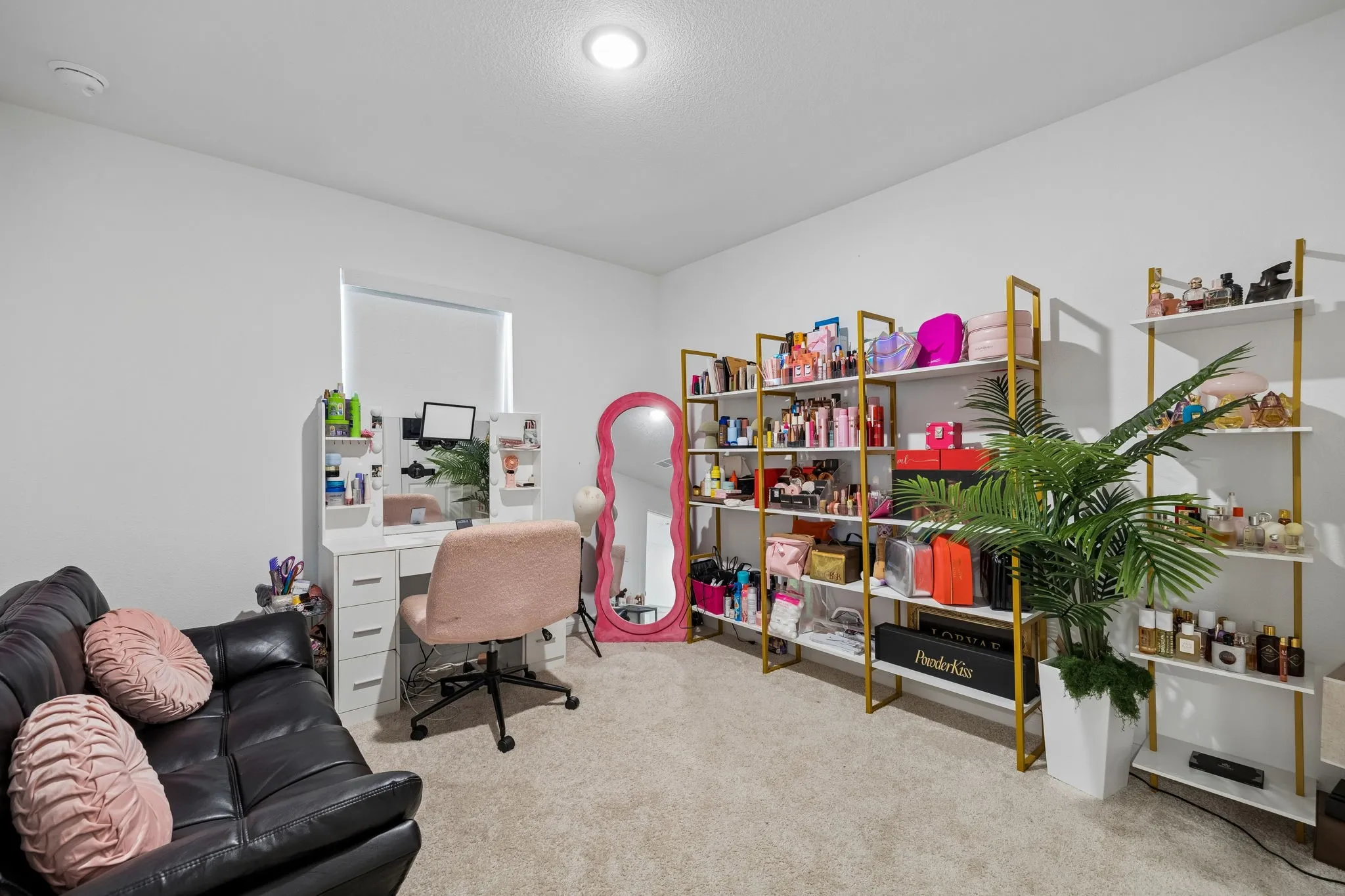 Recessed lighting illuminates a spacious room featuring light-colored carpeting