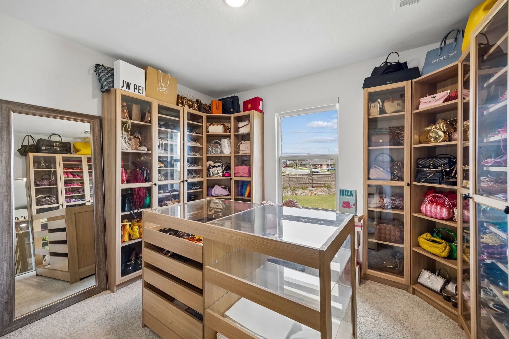 Customizable closet system featuring wood-finish cabinetry with glass-front doors