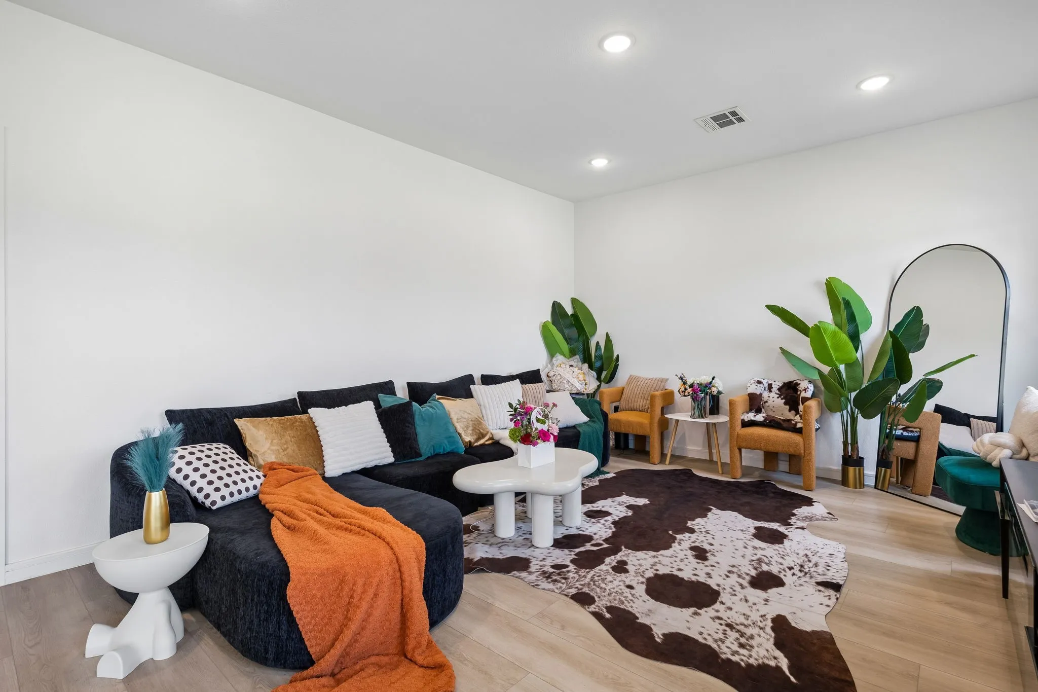 Open-concept living space featuring light wood-finish flooring, recessed ceiling lighting, and crisp white walls