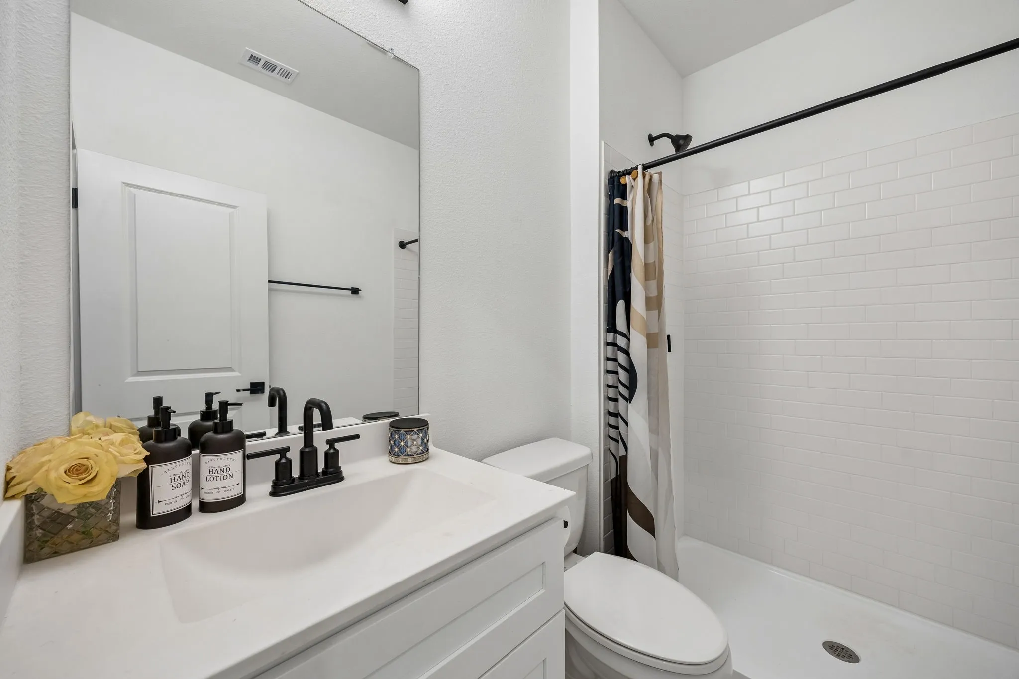 Bathroom featuring a white vanity with a rectangular undermount sink, matte black faucet, and a large wall mirror