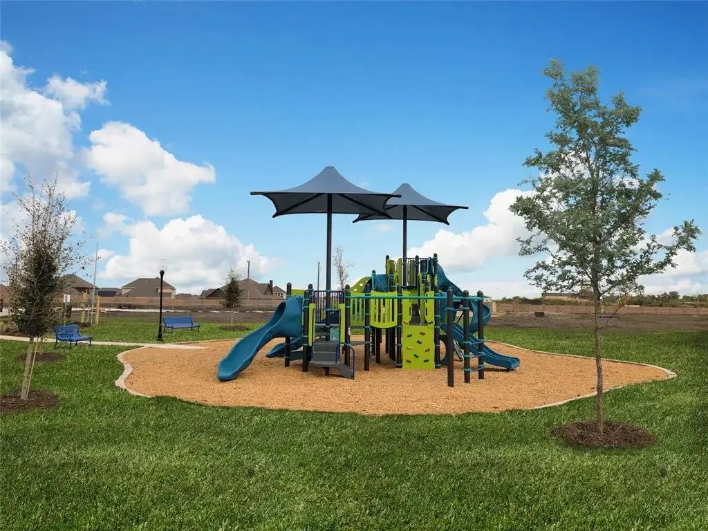 Recreational playground area featuring multiple slides, climbing structures, and protective shade canopies