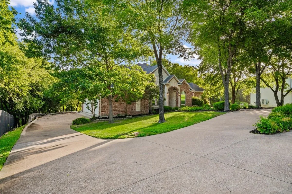 Split concrete driveway providing access to a brick and siding residence