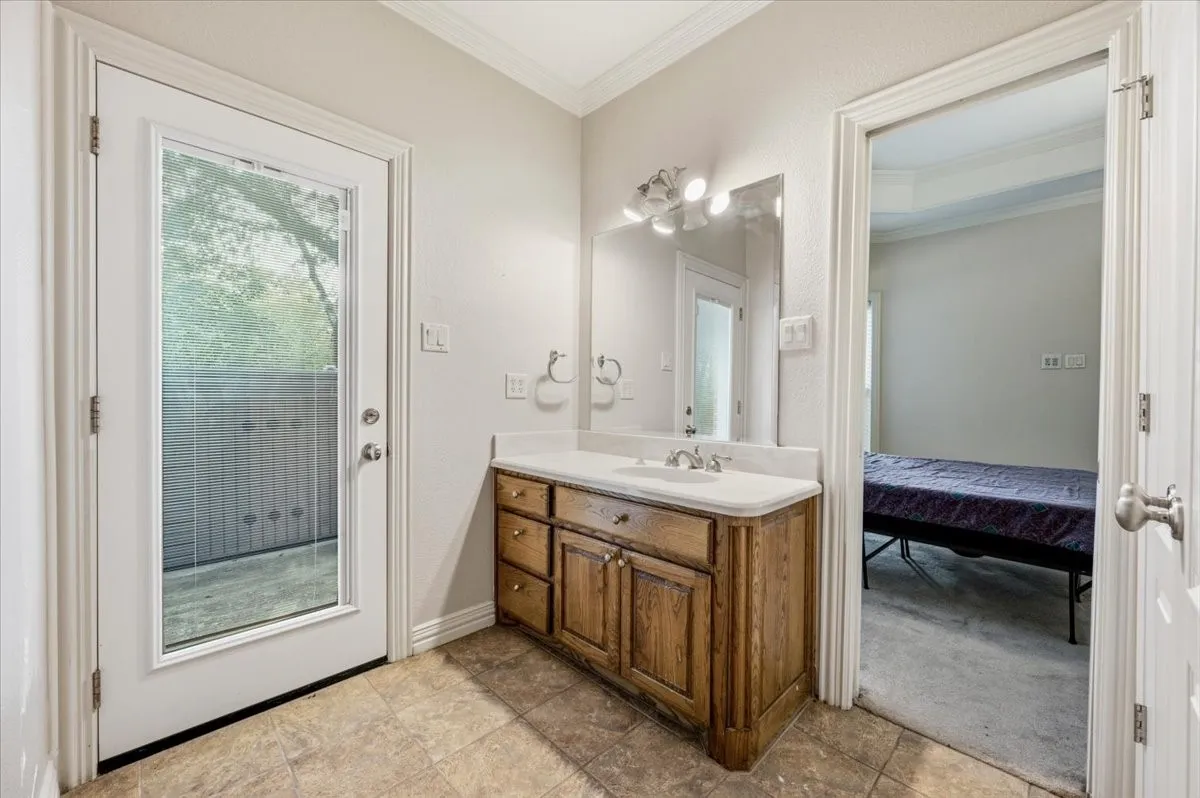 Vanity area featuring a wood-finish cabinet with a white countertop and integrated sink