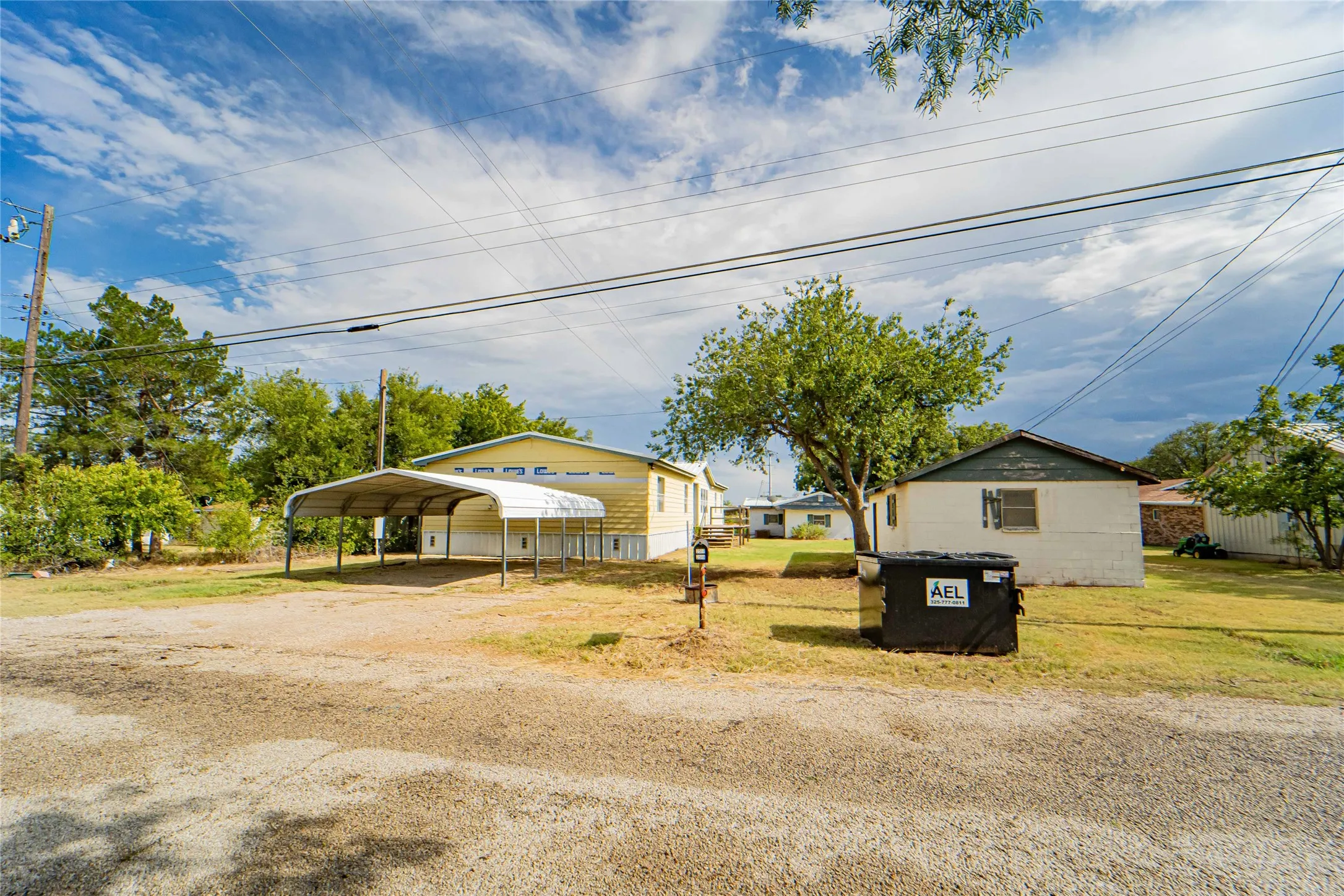 Property exterior featuring a metal carport structure and an expansive grass yard