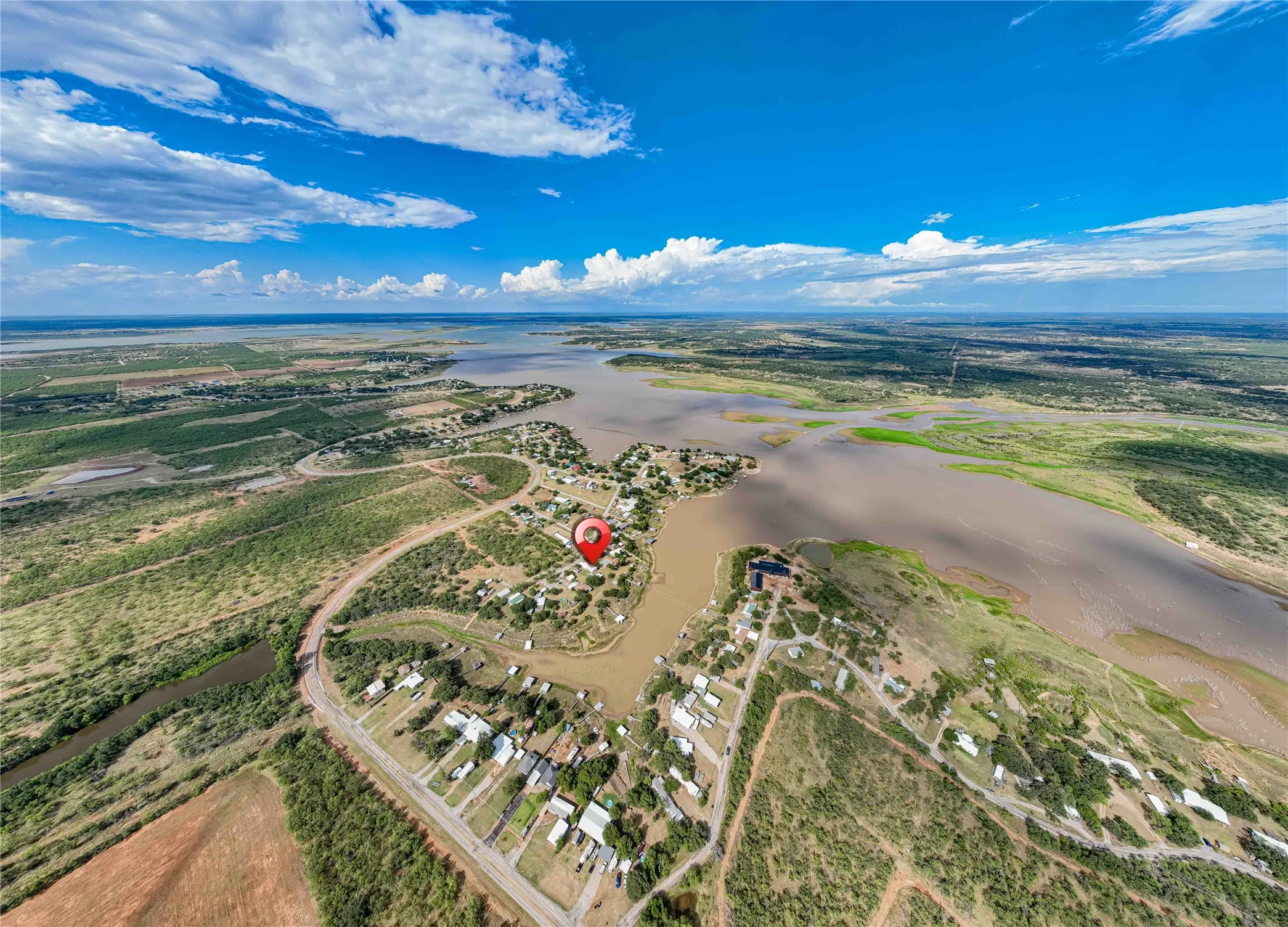 Aerial perspective of a waterfront community featuring extensive water frontage and diverse natural surroundings