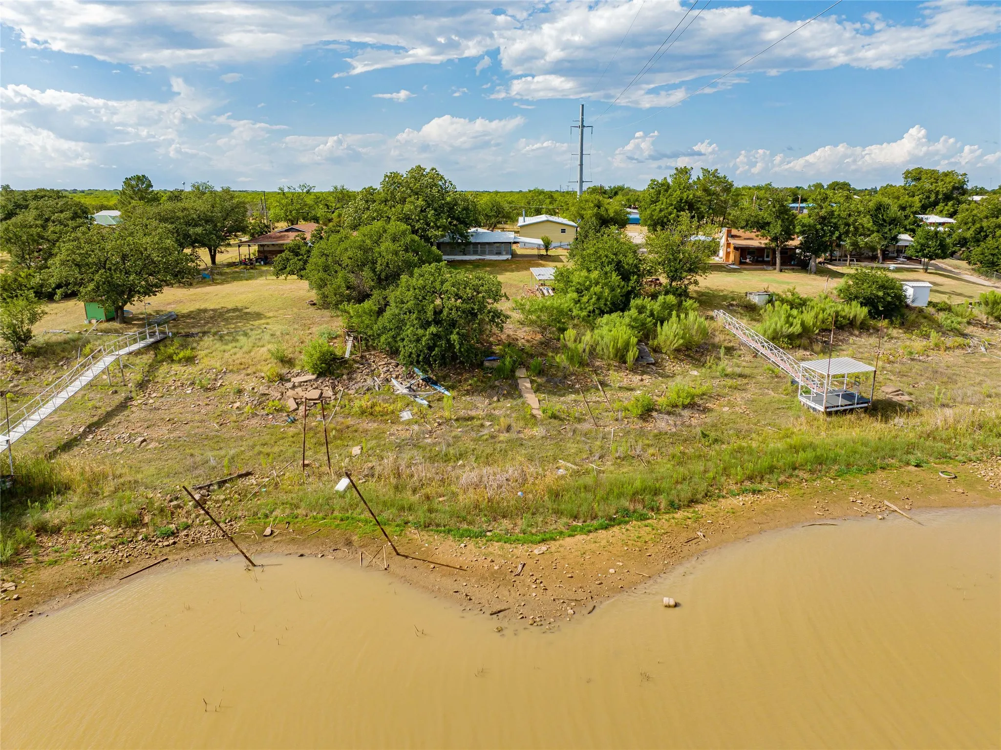 Waterfront property extending to the water, mature trees, and natural landscaping