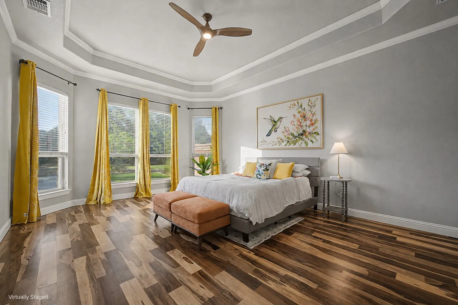 Main-level primary suite offers generous dimensions, natural light, and privacy within the home’s three-way split-bedroom floor plan.