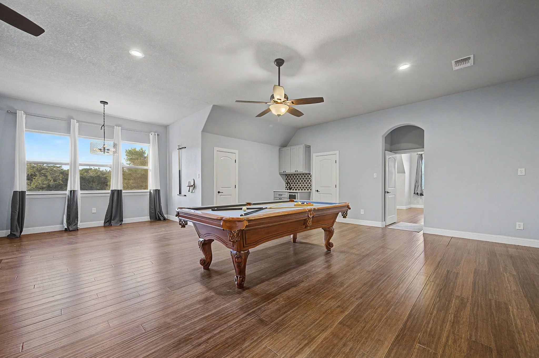 Versatile alcove off the game room creates a defined space for a reading nook, study area, or home office.