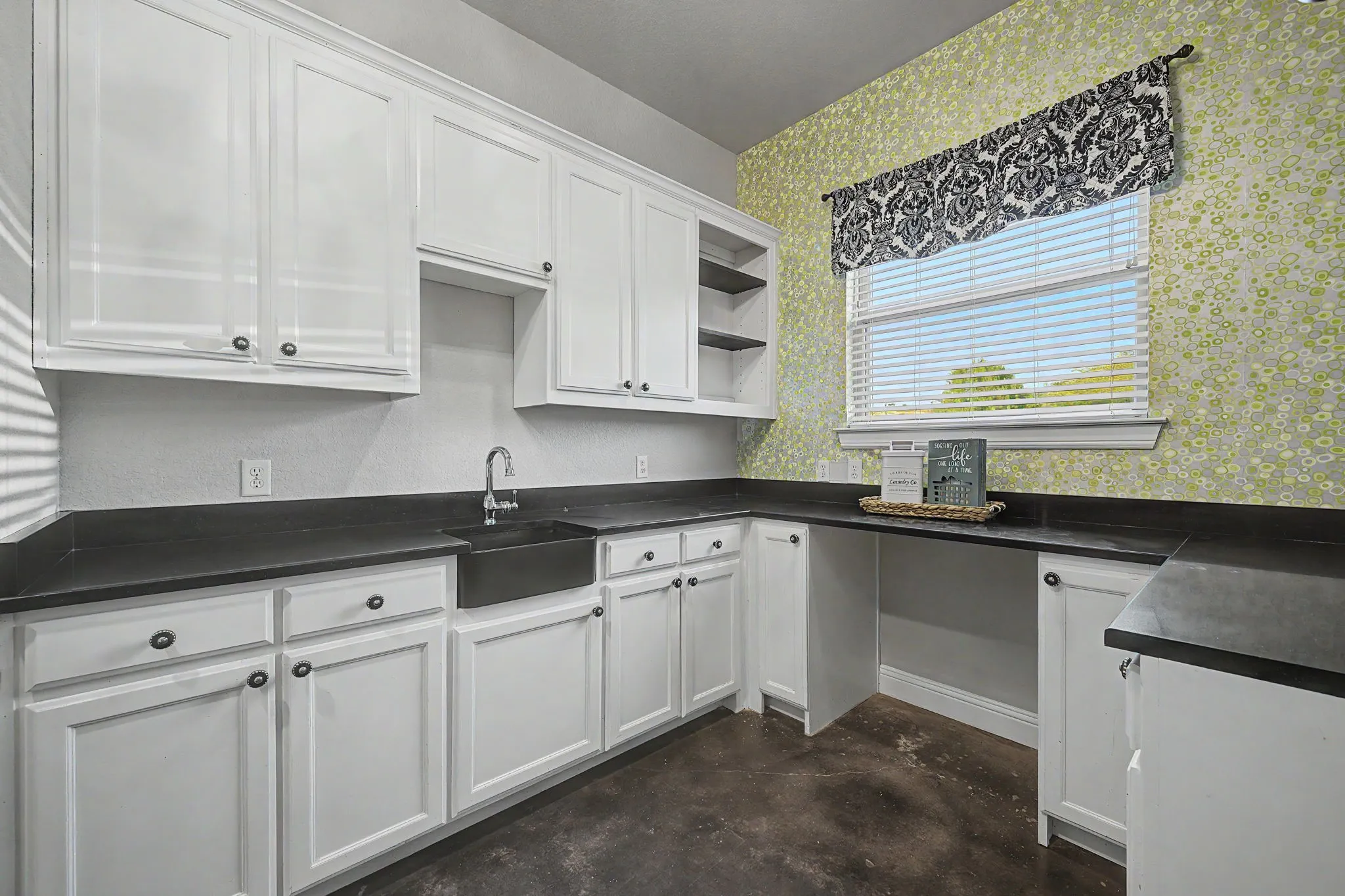 Dedicated laundry room with cabinetry and space for household storage.