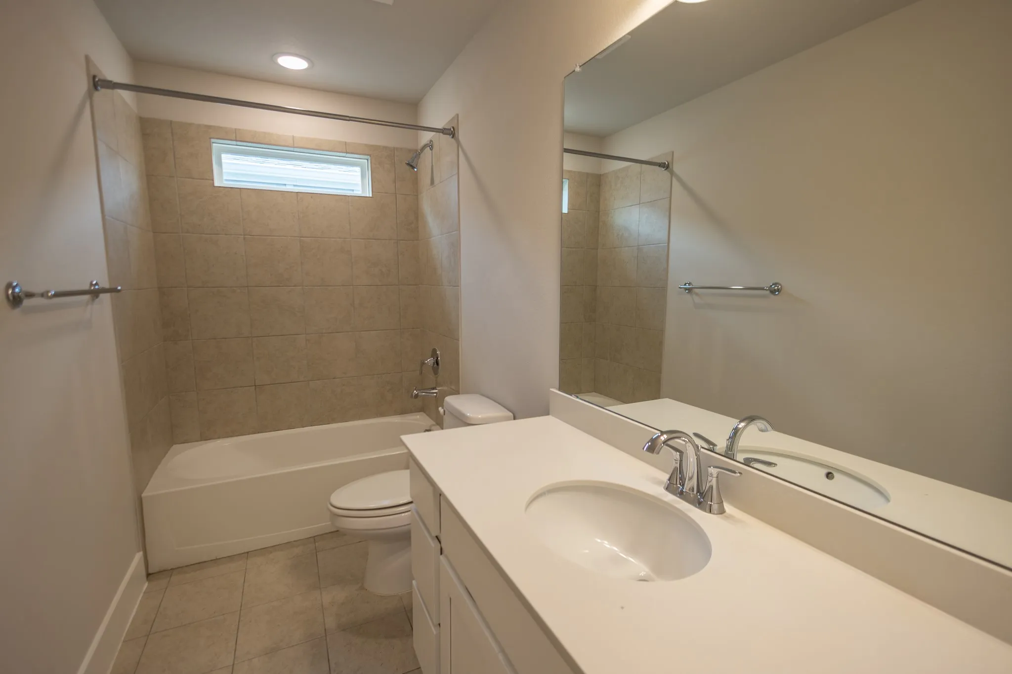 Bathroom featuring a white vanity with an integrated sink and chrome fixtures