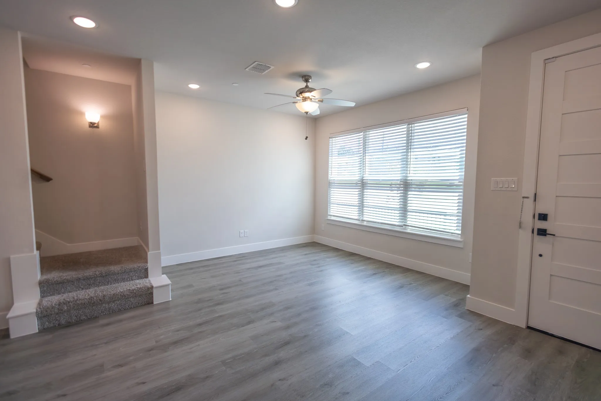 Beautiful flooring with a large window for natural light and ceiling fan with light.