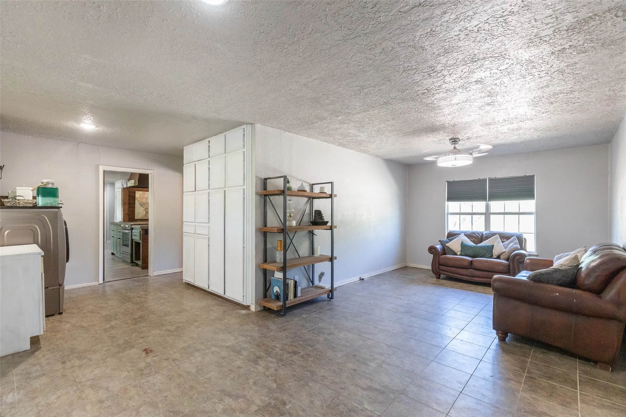 Open-concept living area featuring tile flooring, neutral wall tones, and recessed lighting