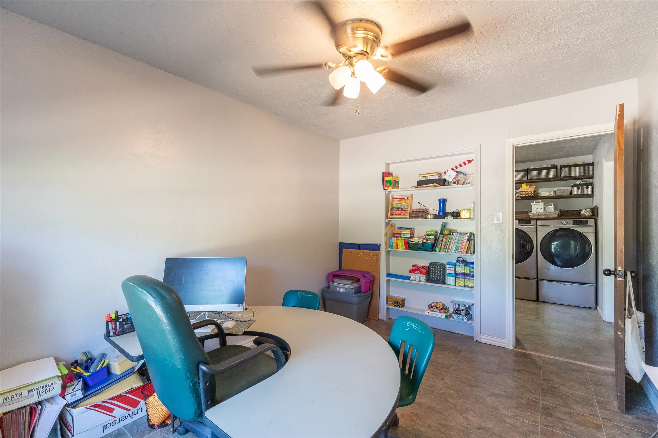 Room featuring tile flooring and a ceiling fan with light fixture