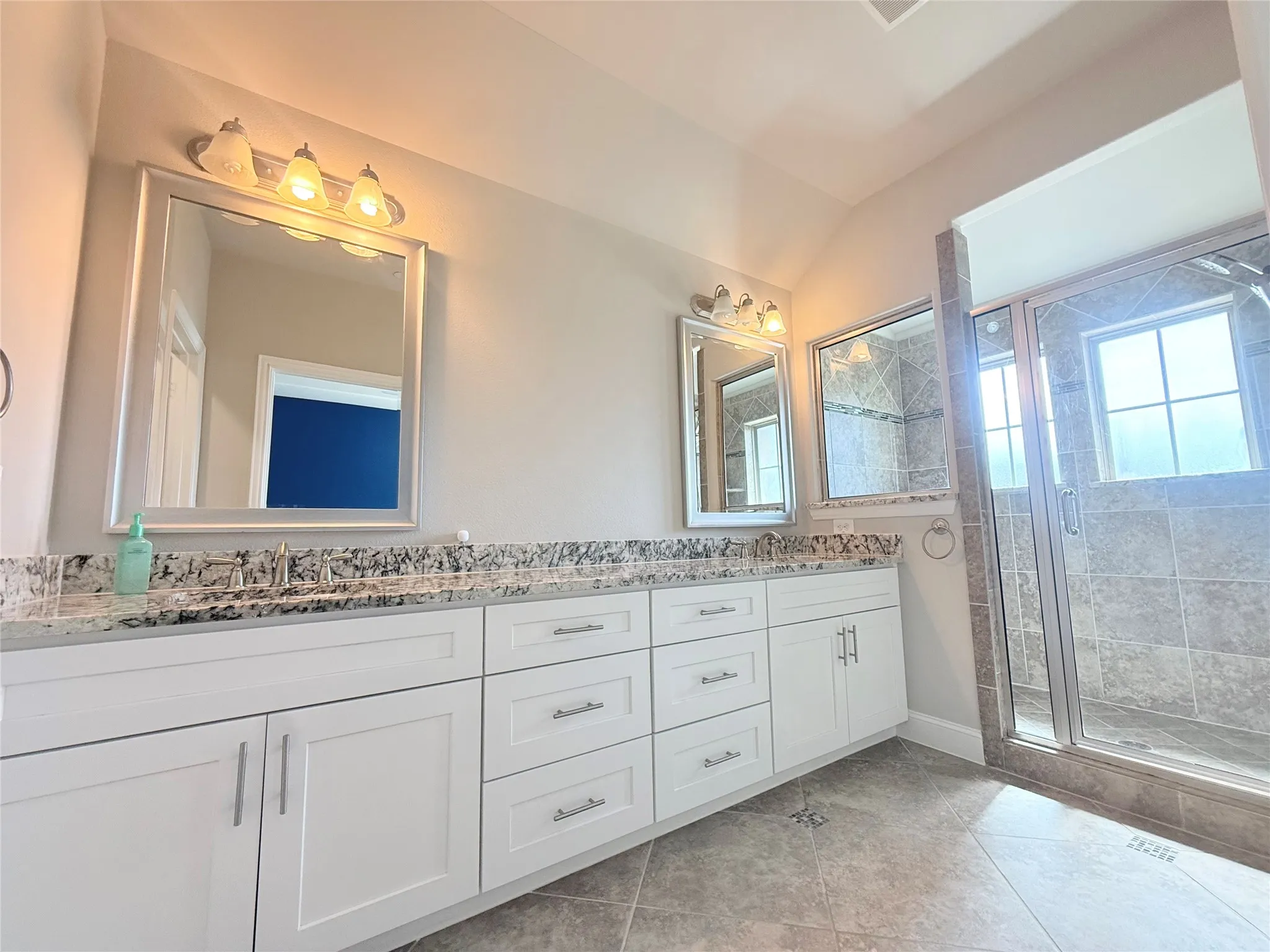Bathroom vanity with dual sinks, framed mirrors, and chrome hardware