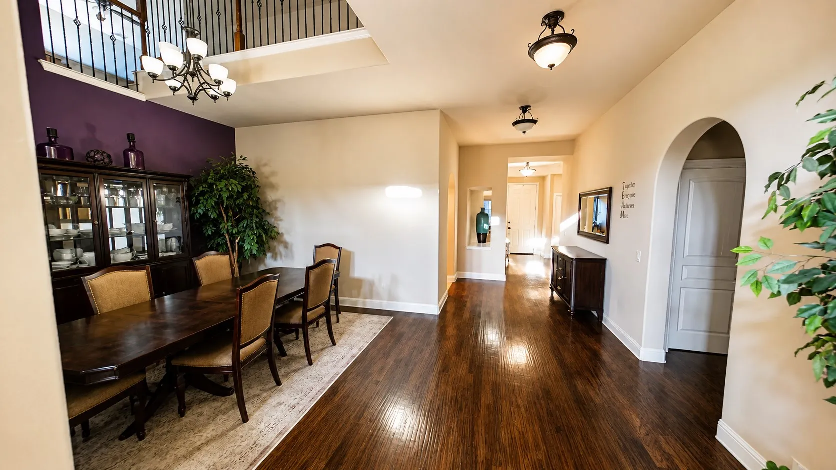 Hardwood flooring, arched doorway, recessed wall niche, two-story ceiling, wrought iron baluster railing