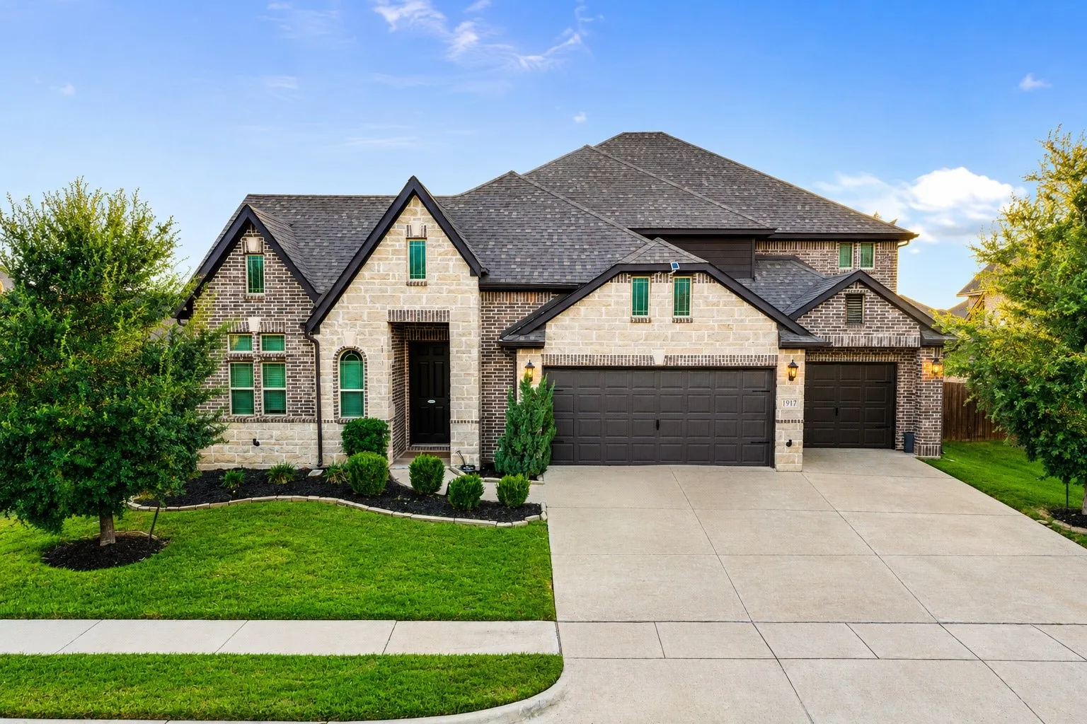 Brick and stone facade with dark shingles