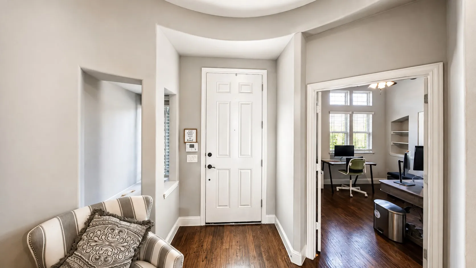 Wood-finish flooring throughout, with a paneled entry door and a coved ceiling detail