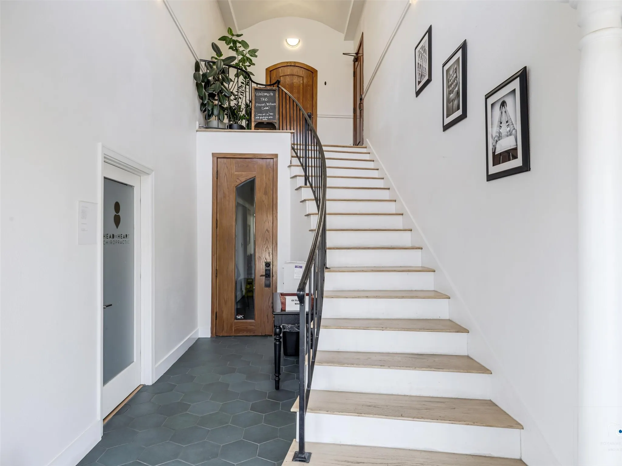 Curved staircase with black metal railing and wood-finish treads