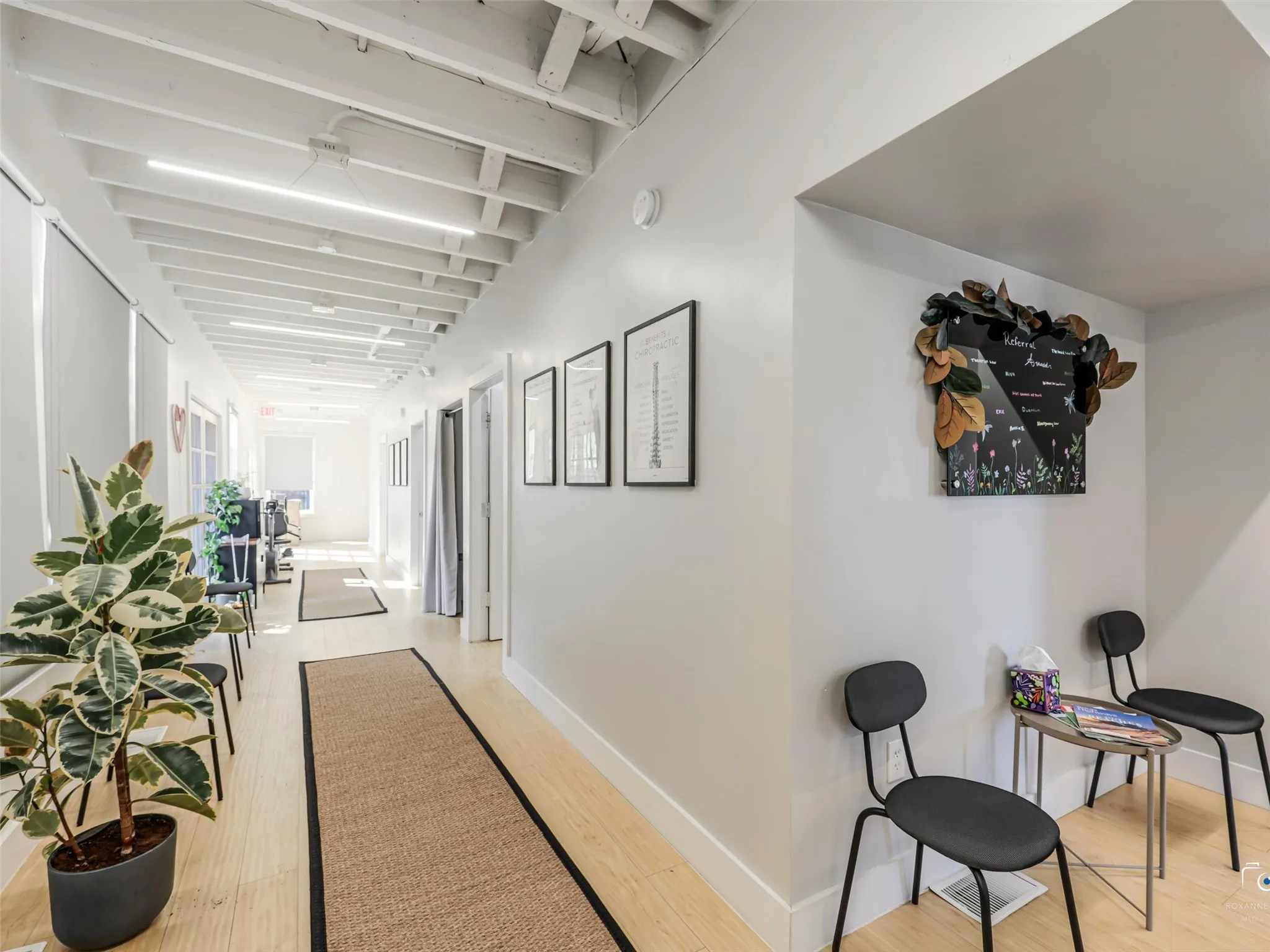 Bright hallway with exposed beam ceiling, recessed lighting, wood-finish flooring, and multiple doorways