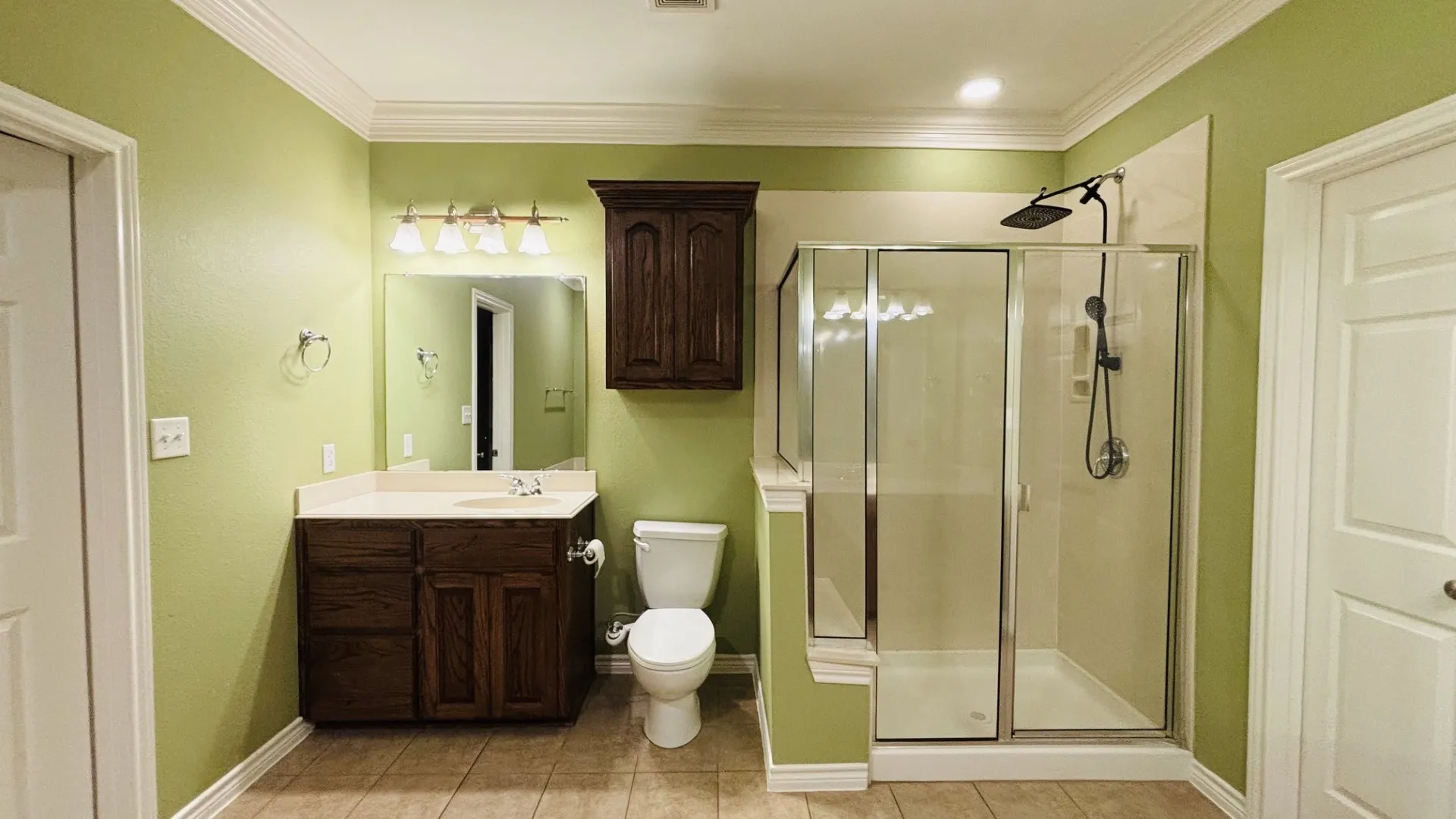 Separate oversized shower stall with adjustable overhead rainfall showerhead and sprayer.