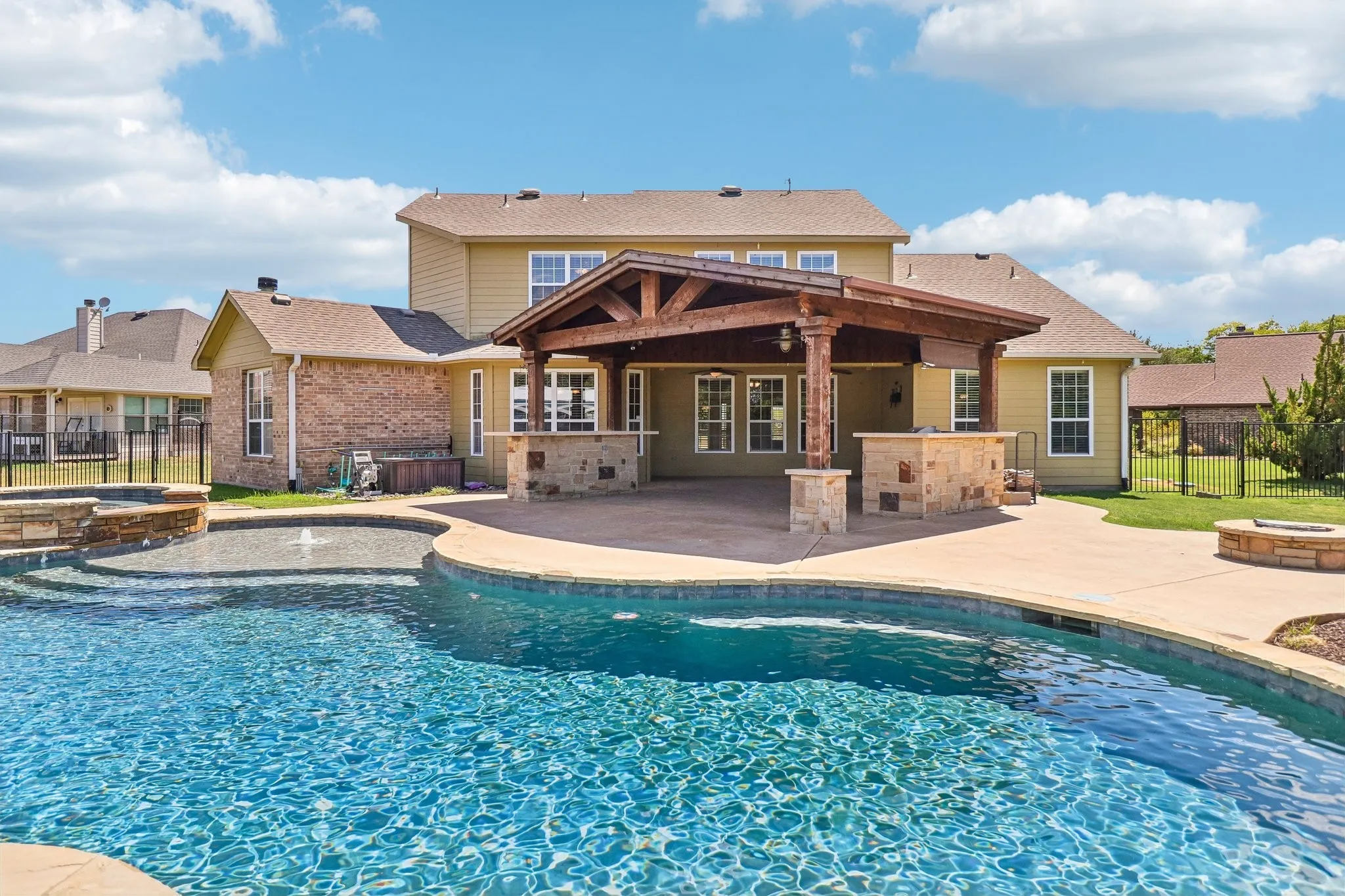 Entertain family and friends in this beautiful pool and spa, outdoor kitchen, bar and living area.