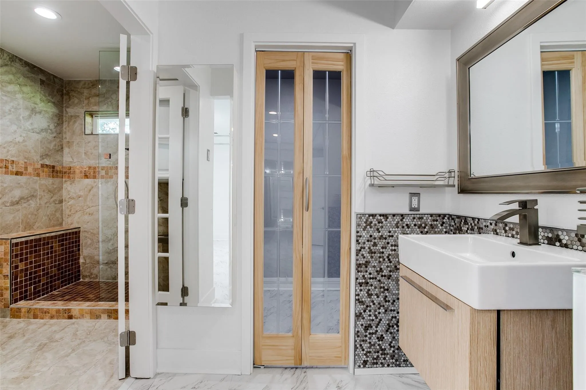 Modern bathroom featuring a rectangular vessel sink with a wall-mounted faucet, wood-finish vanity, and mosaic tile backsplash