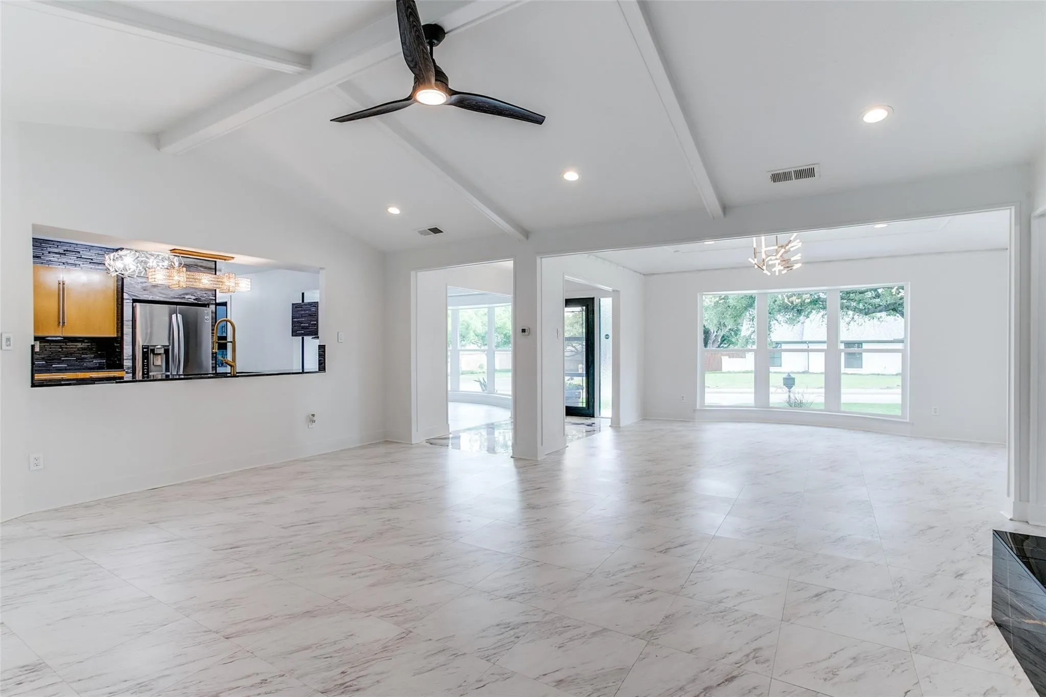 Open-concept living area with vaulted ceilings and exposed beams
