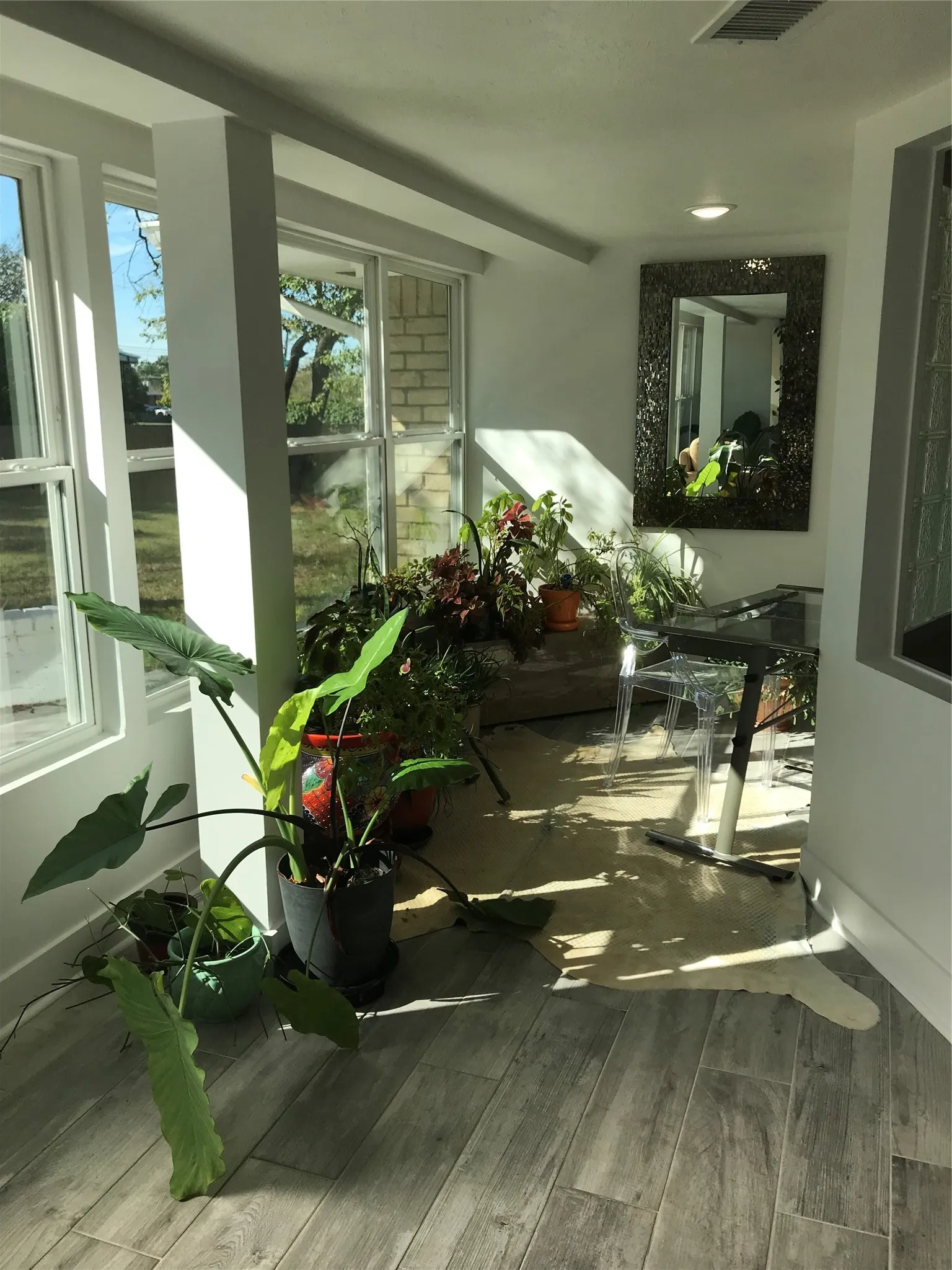 Room featuring multiple windows, recessed lighting, and wood-finish flooring