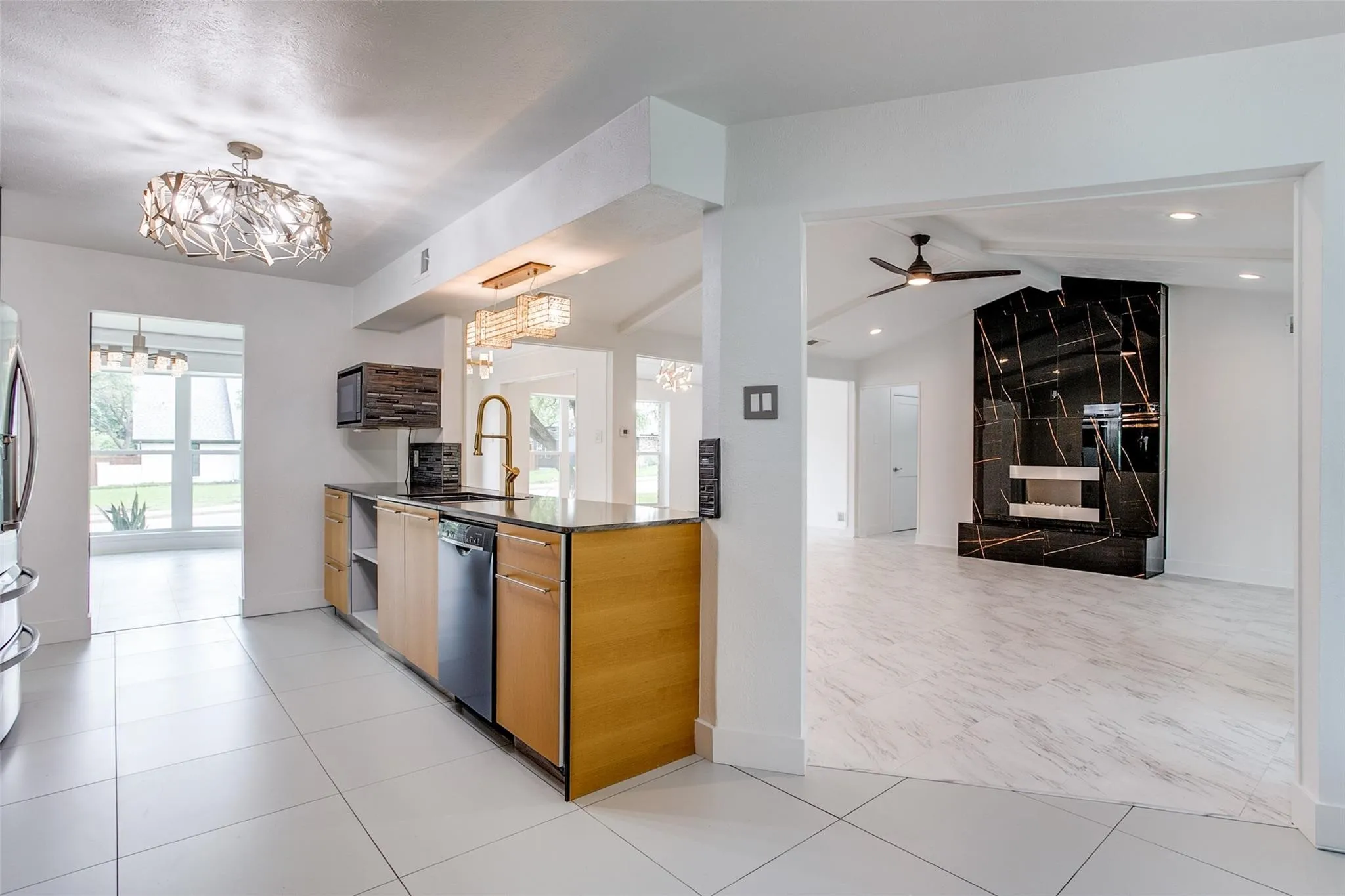 Kitchen area featuring light wood-finish cabinetry, dark countertops, and stainless steel appliances