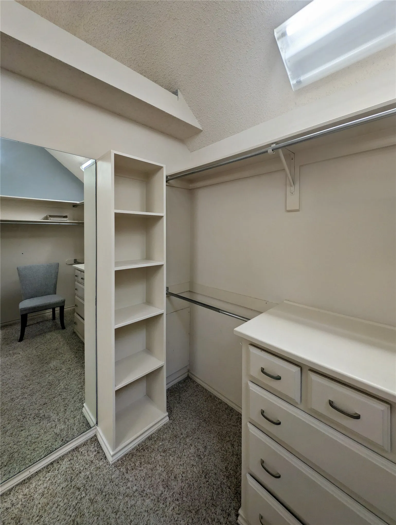 Spacious laundry room featuring extensive upper and lower cabinetry, a utility sink with a chrome faucet, and ample counter space