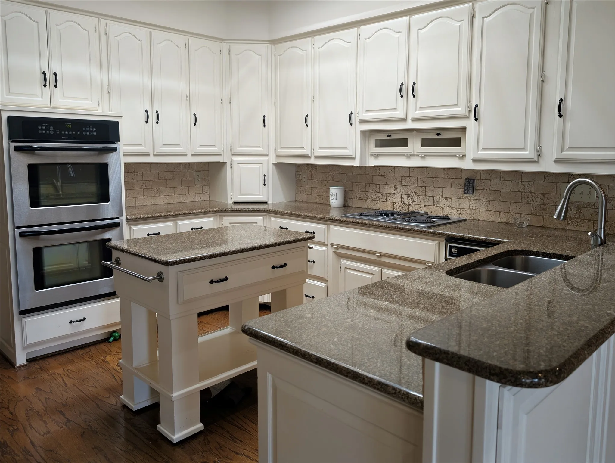 Kitchen featuring white cabinetry, dark wood-finish flooring, and speckled countertops