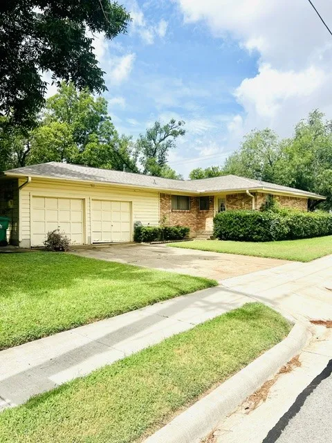 Ranch-style residence featuring a brick and siding exterior, a two-car garage, and a concrete driveway