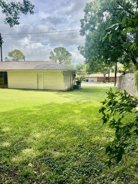 Expansive green lawn with mature trees providing natural shading