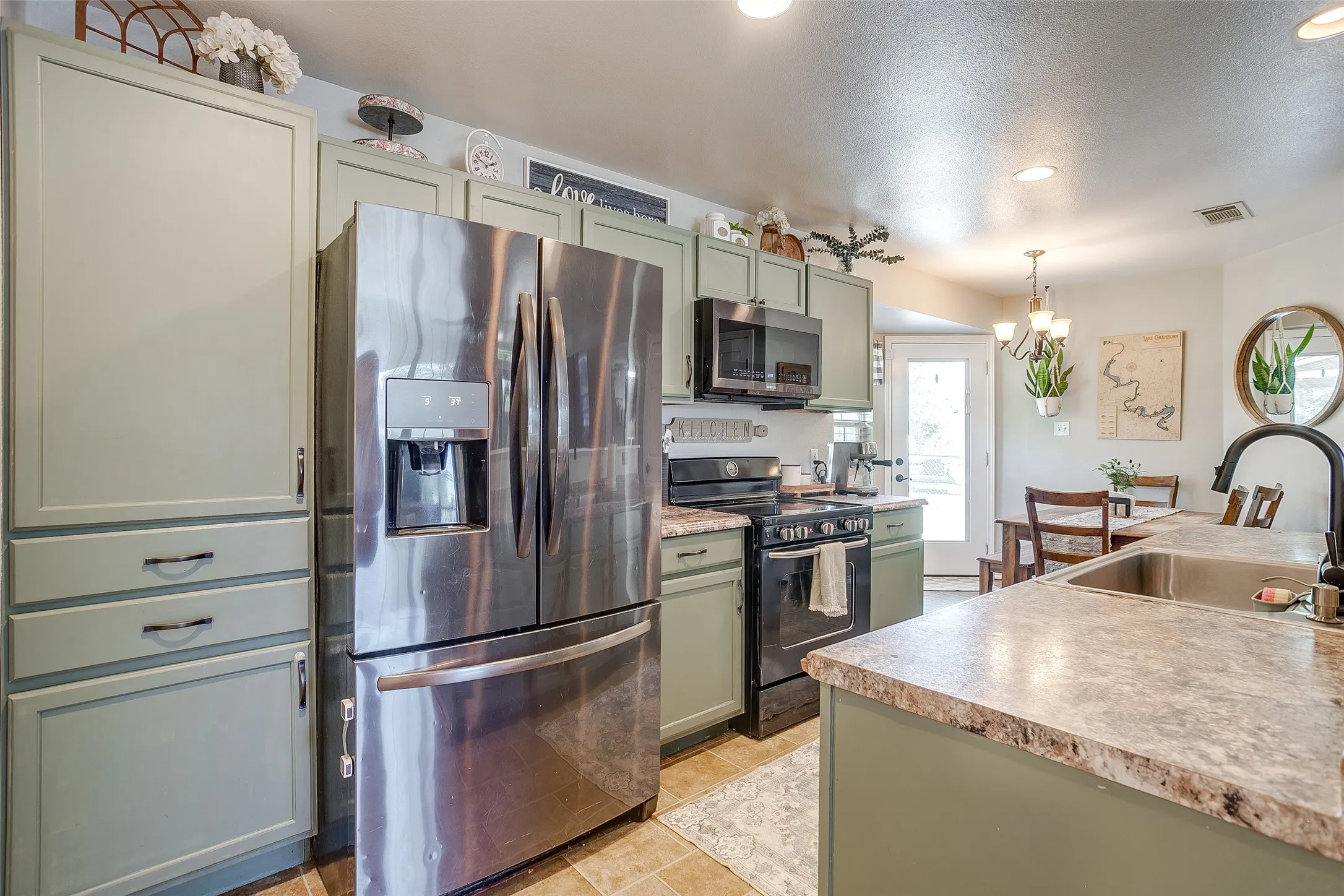 Kitchen featuring stainless steel French door refrigerator, black range, and black microwave
