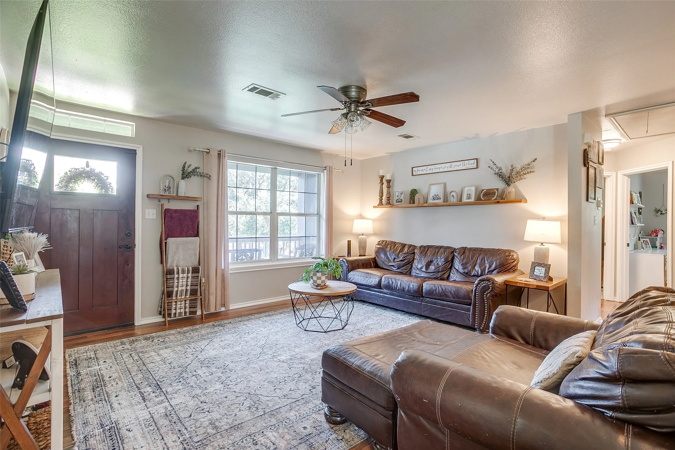 Inviting living area featuring wood-finish flooring and a ceiling fan