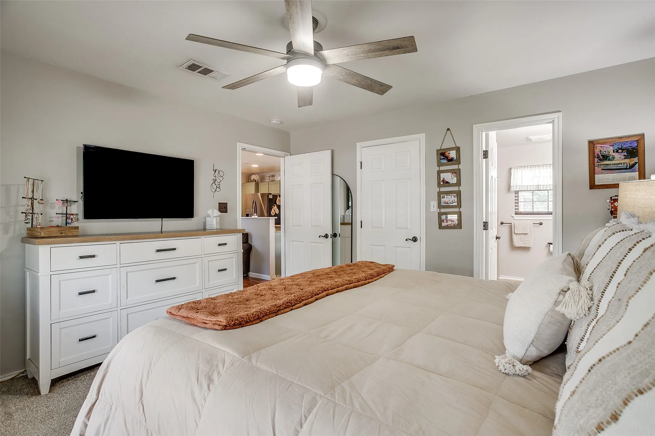Bedroom featuring a ceiling fan with integrated lighting, soft gray wall paint, and carpeted flooring