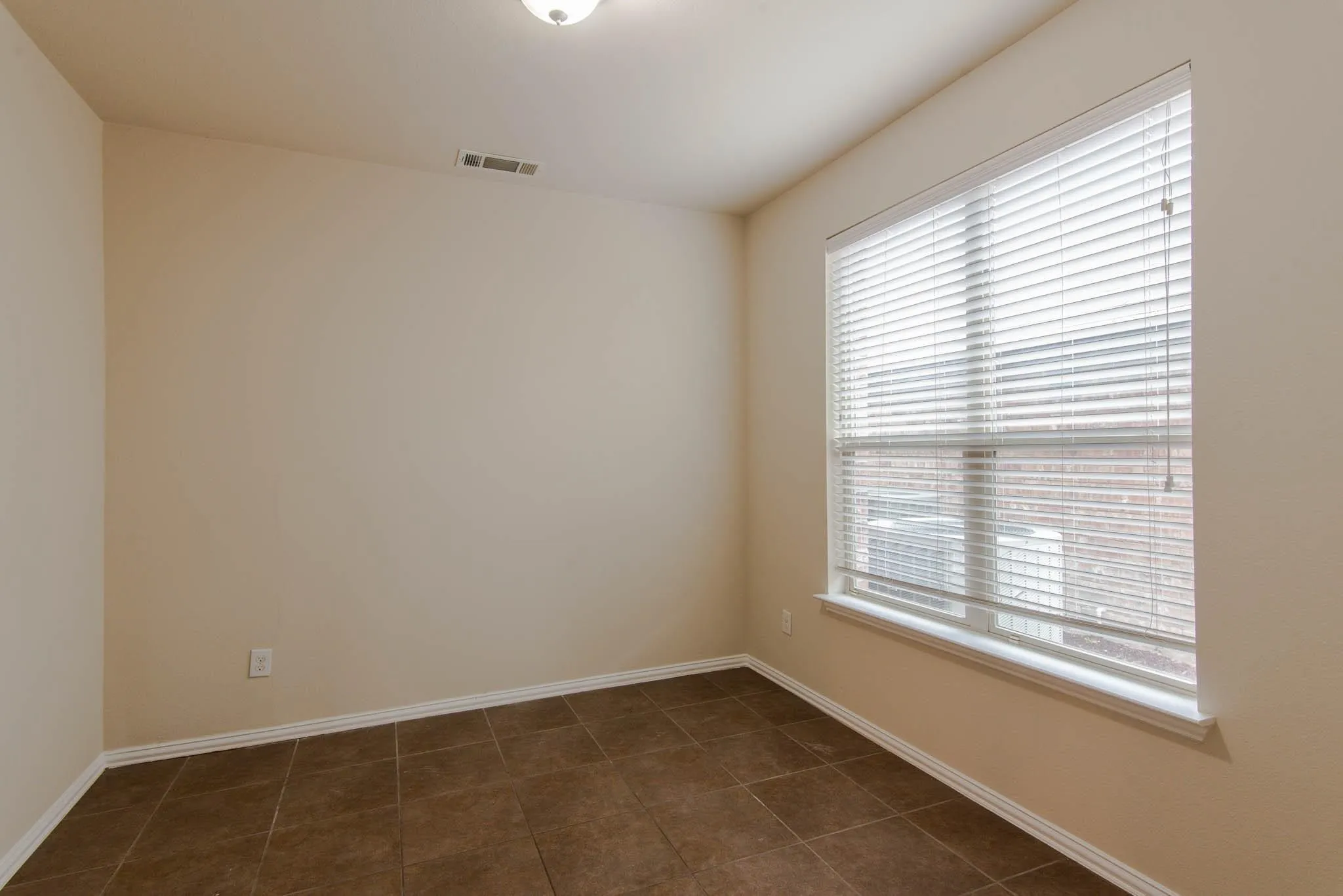 Neutral wall paint complemented by brown tile flooring